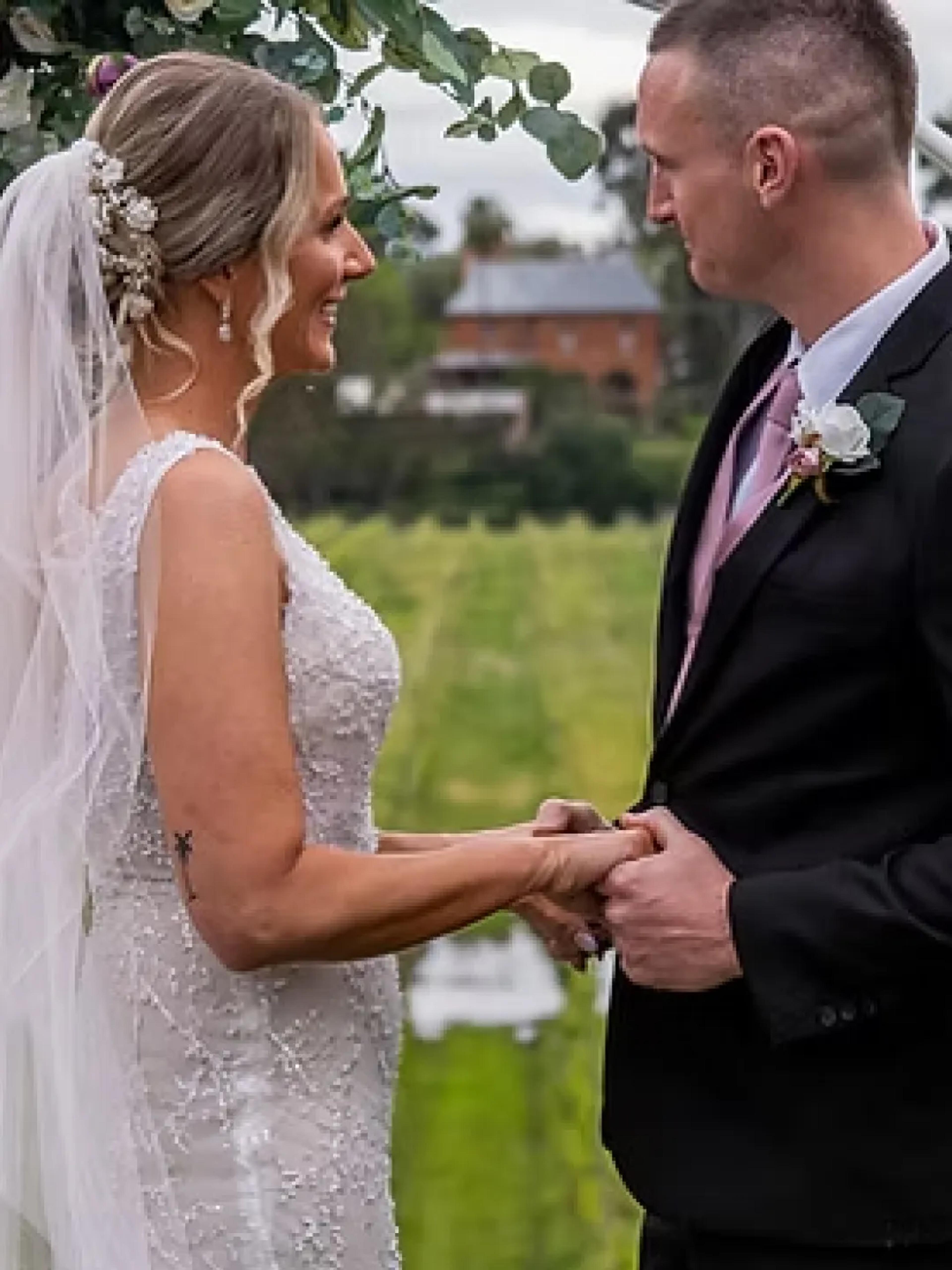 A photo of a man and woman holding hands, getting married.