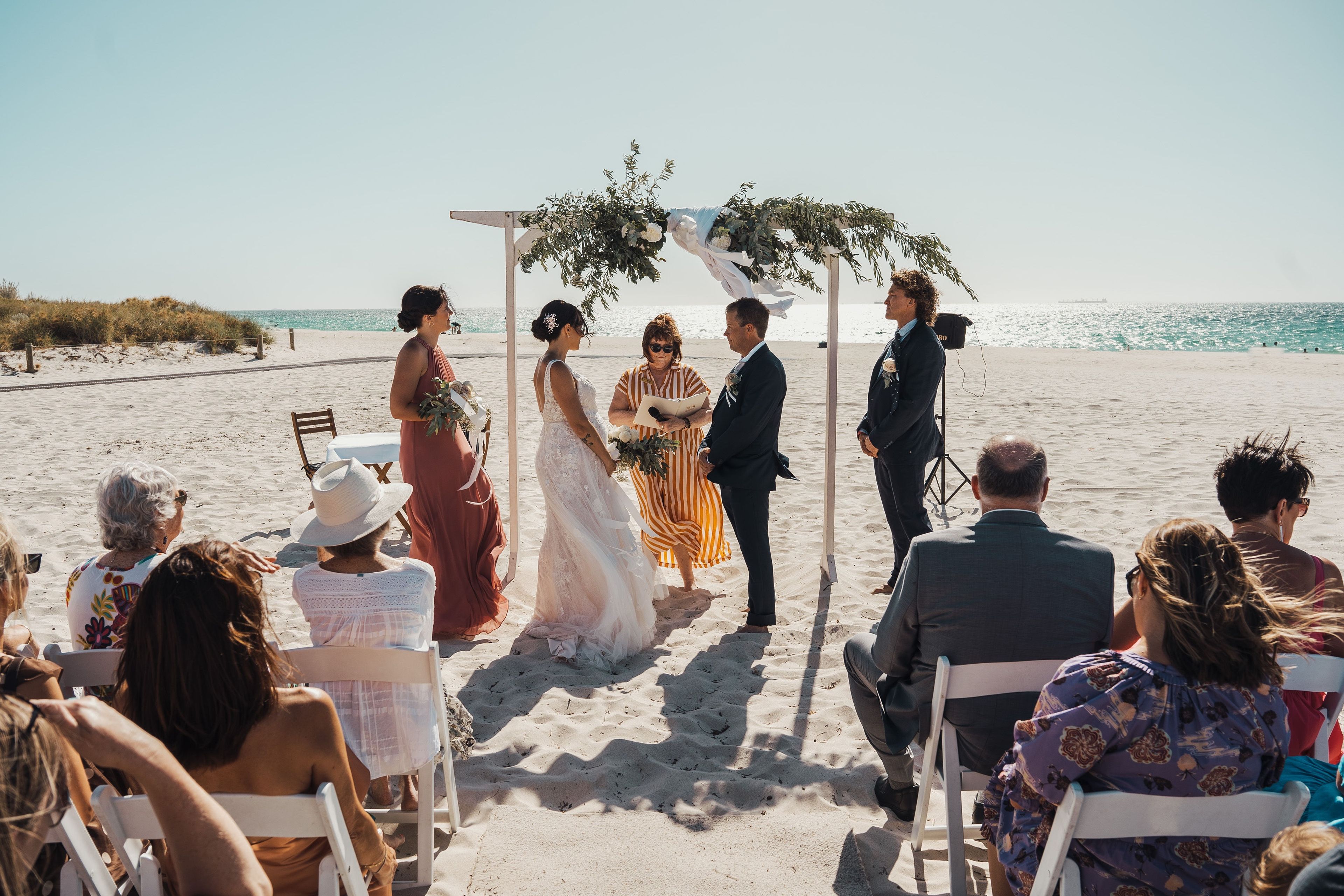 A photo of a couple sitting at a table on the beach.