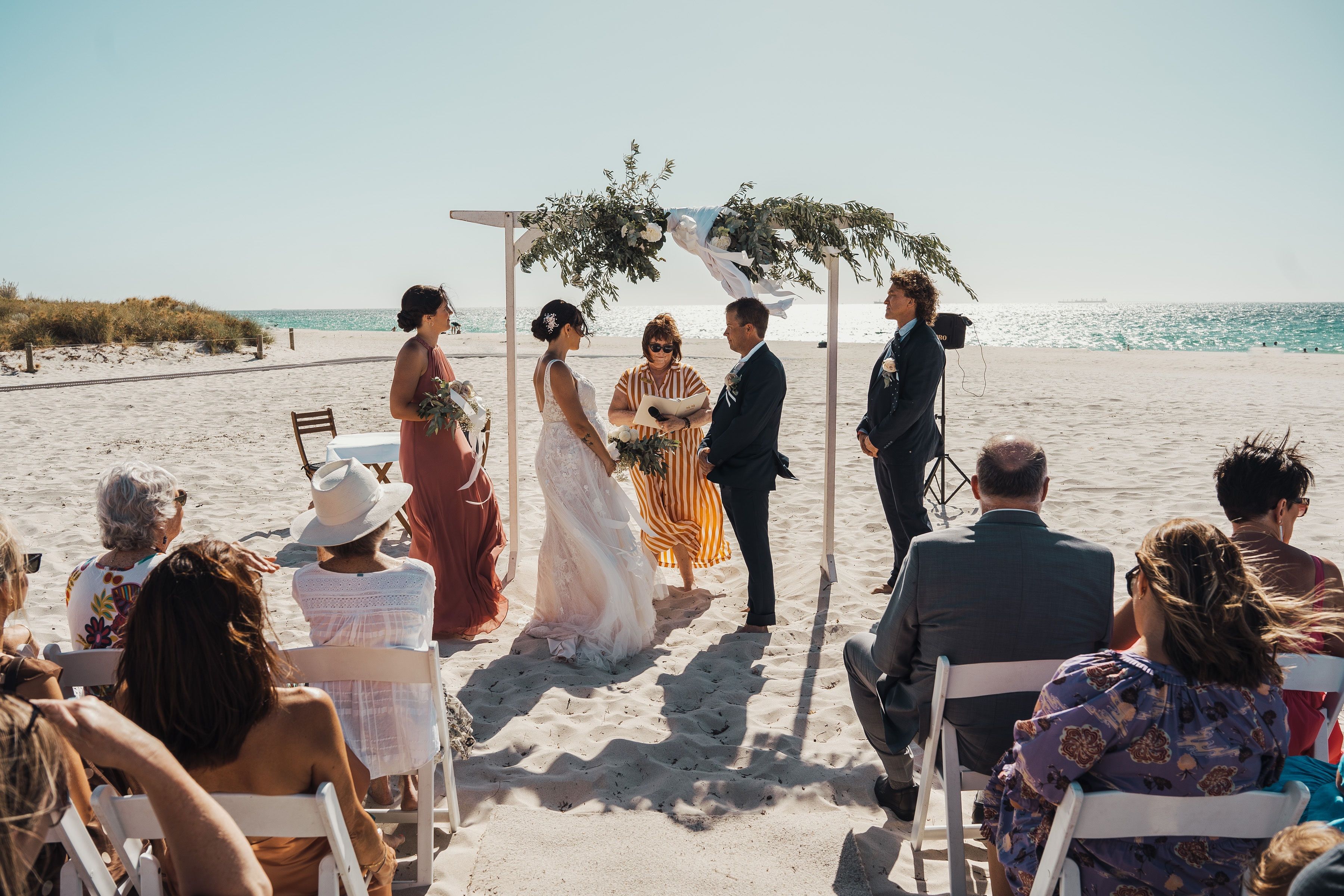 A photo of a couple sitting at a table on the beach.