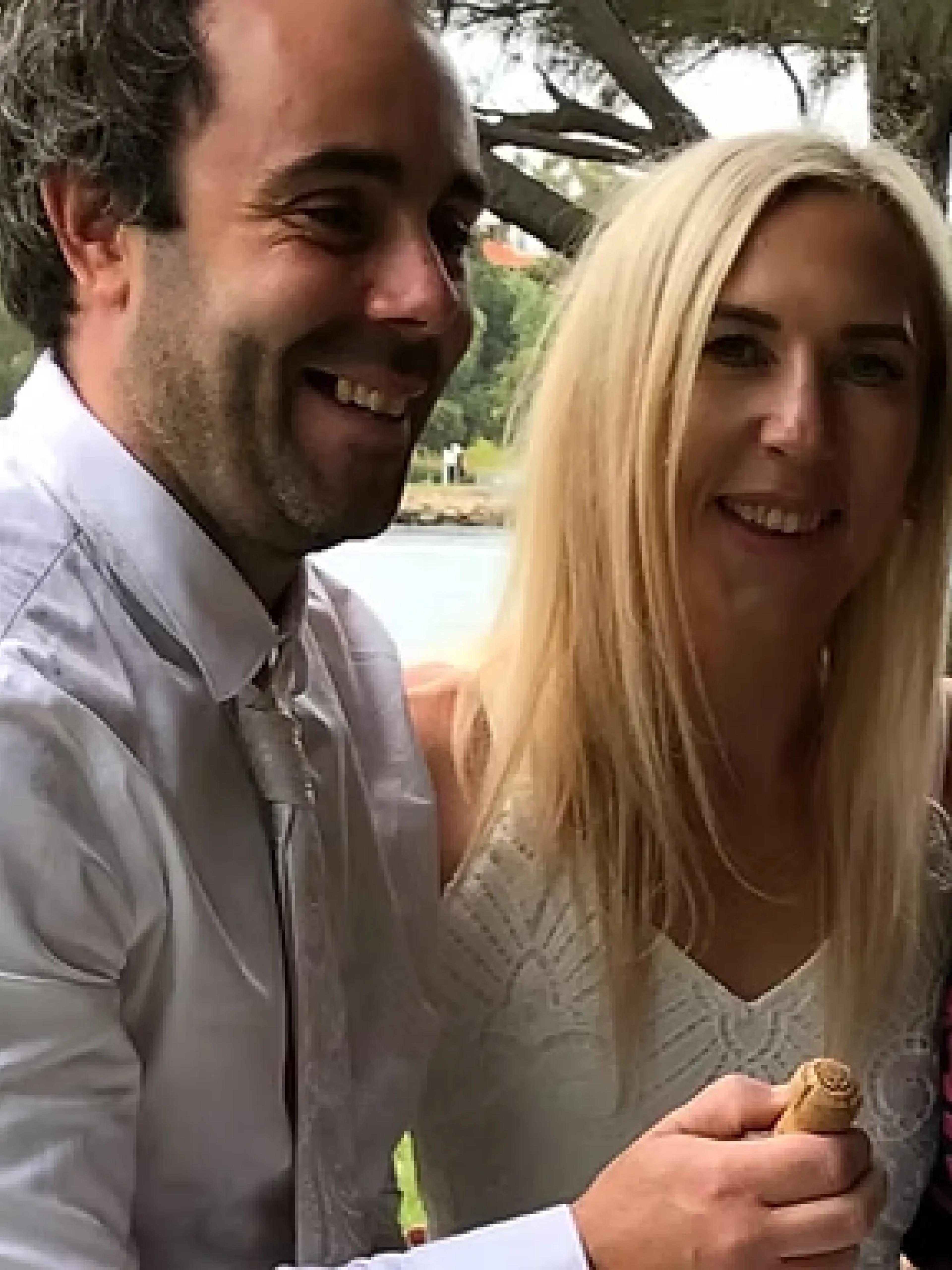 A photo of a couple standing with Jill and smiling.