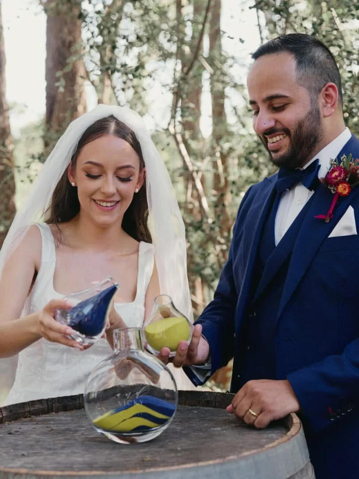 A photo of a couple performing a sand ceremony.