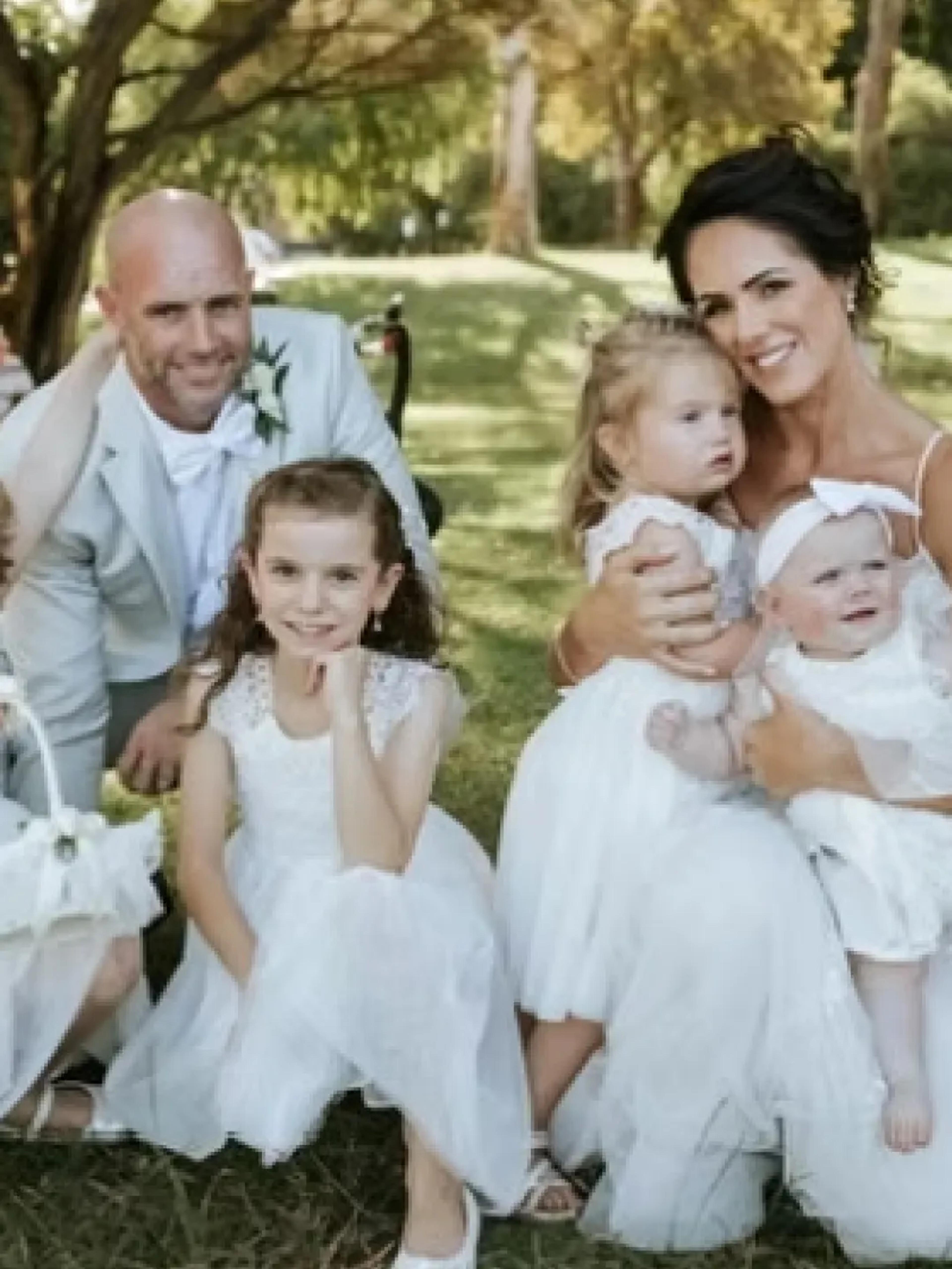 A photo of a newly wed couple with their many kids.