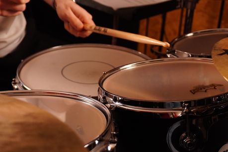 Un batteur qui joue sur les toms d'une batterie