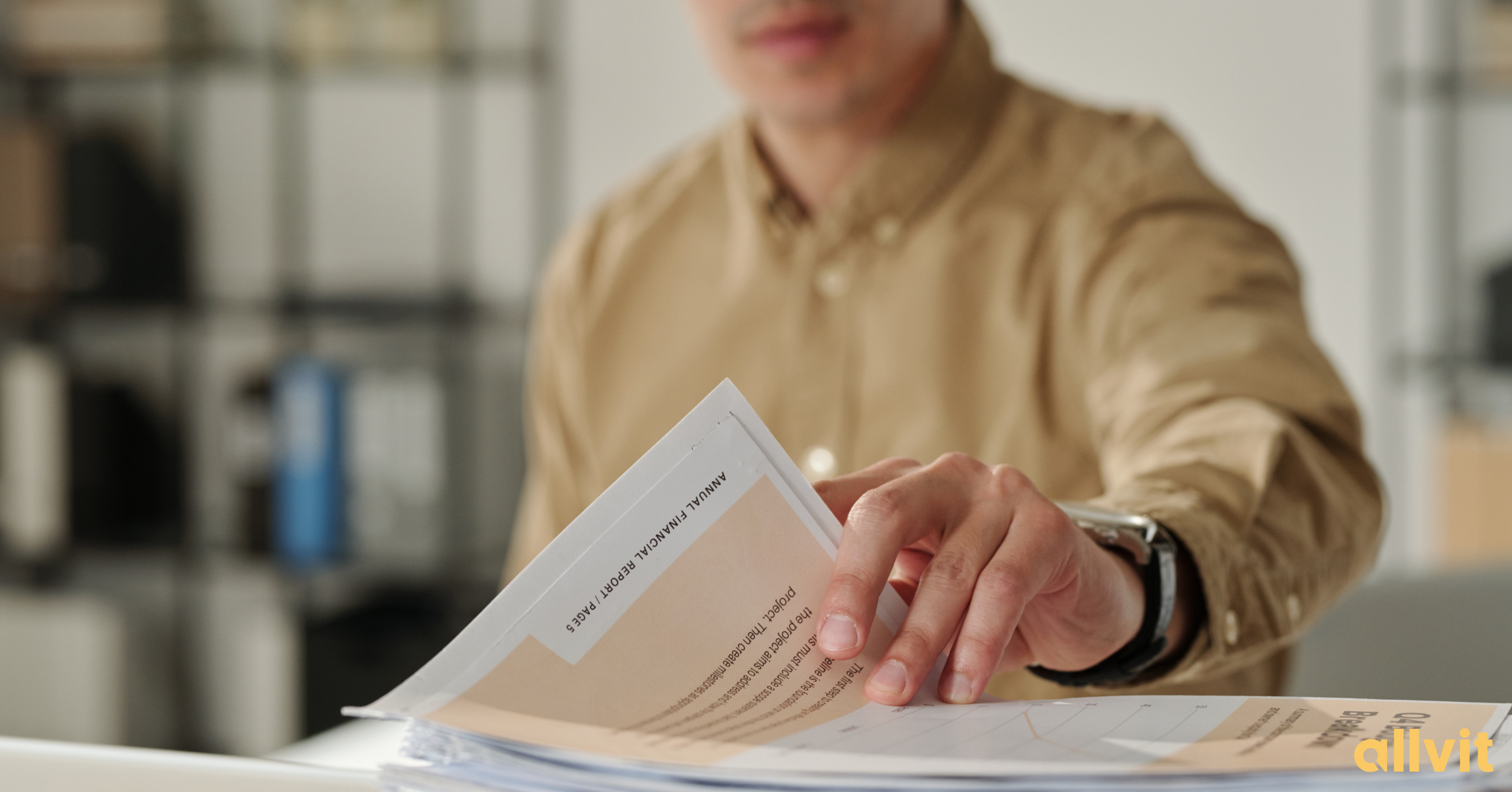 Mannlig økonom som blar i finansrapport. Foto.