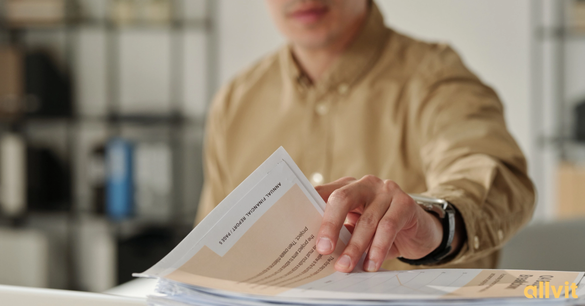 Mannlig økonom som blar i finansrapport. Foto.