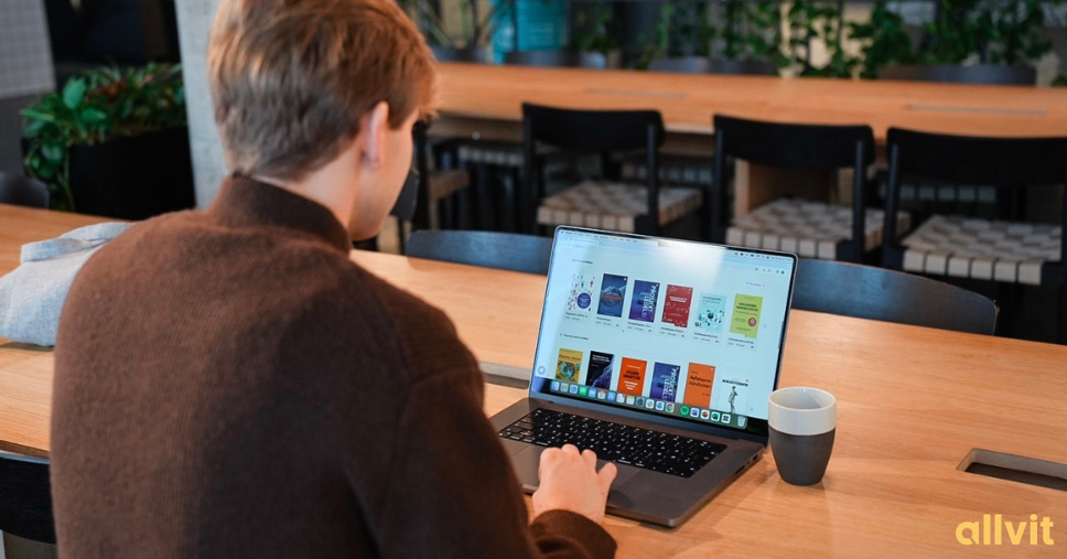 Gutt som sitter foran PCen sin med e-bøker på skjermen. Foto.