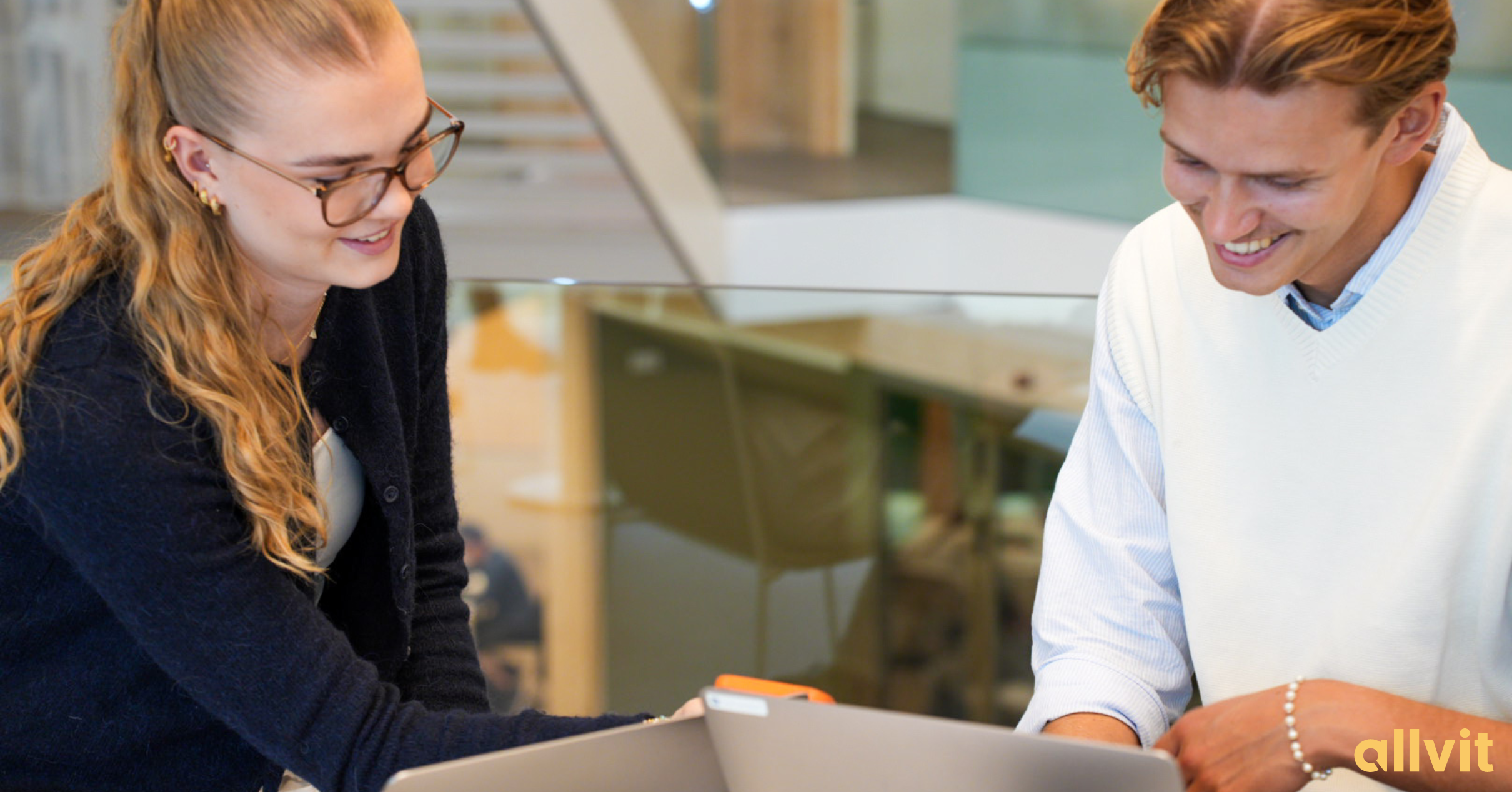 To studenter som ser på PCen og ler. Foto.