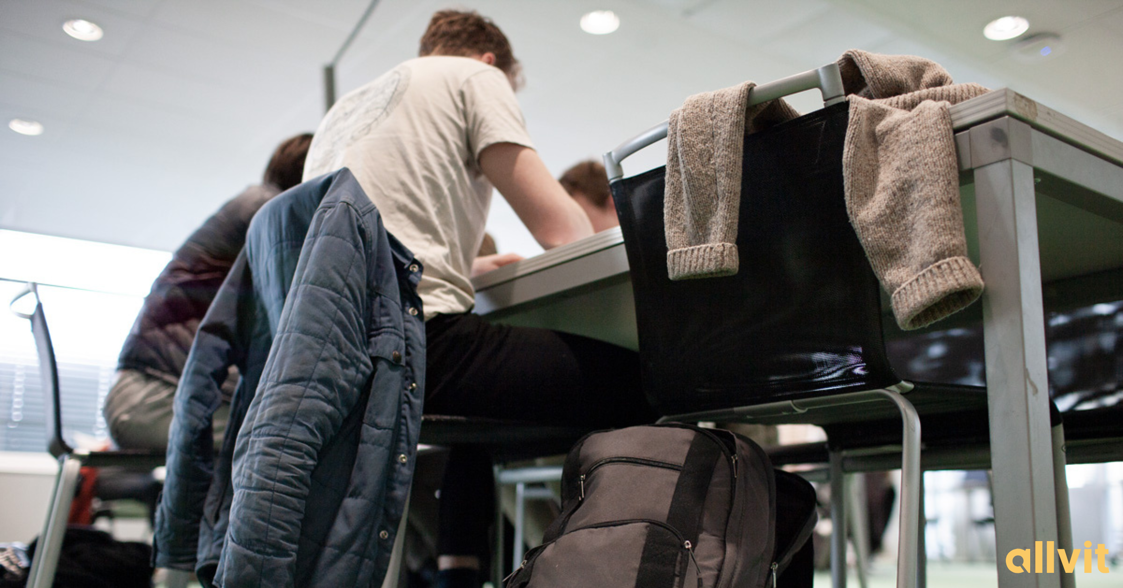 Ung mann ved pulten på campus. Foto.