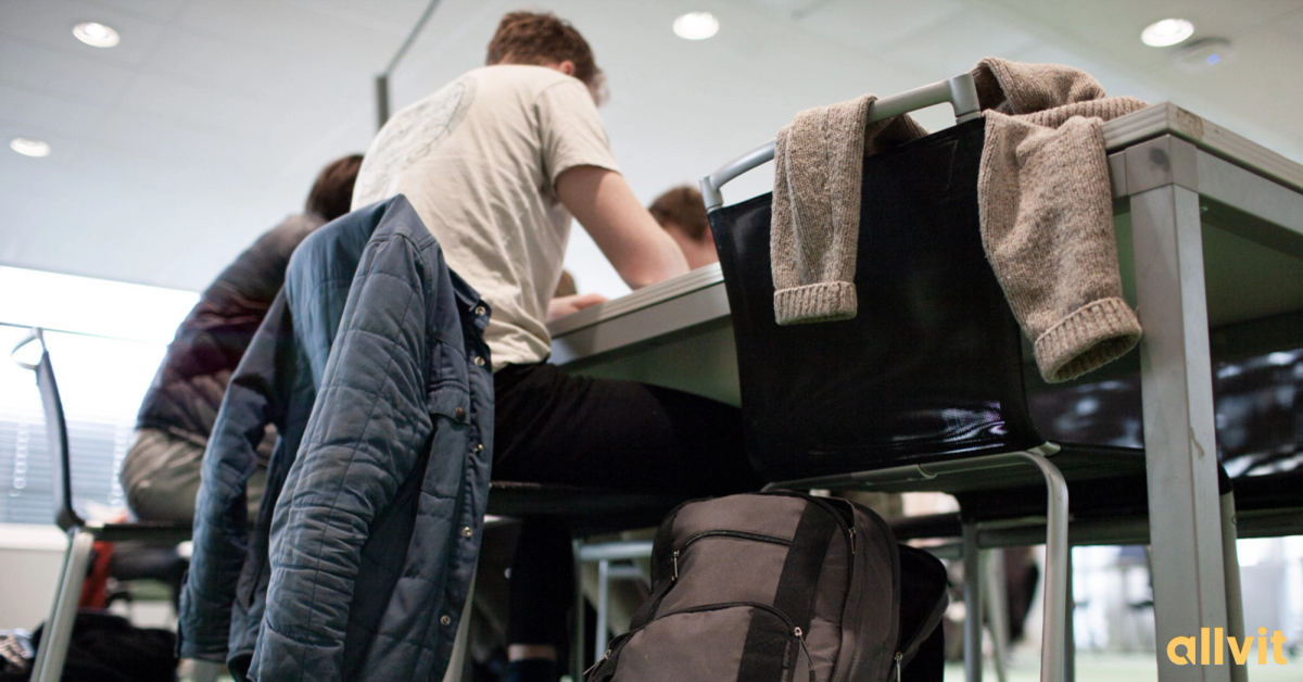 Ung mann ved pulten på campus. Foto.