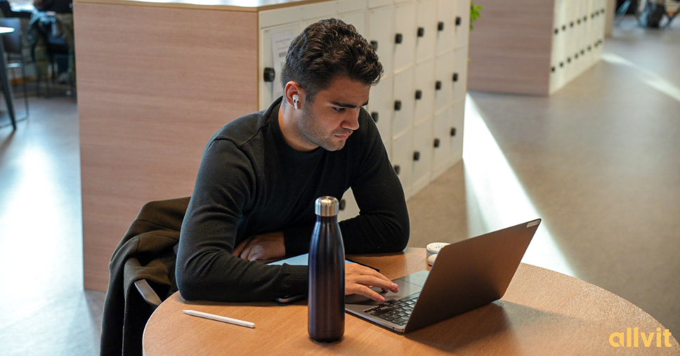 Mannlig student som sitter ved bordet på sin student-PC. Foto.