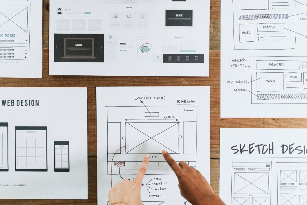 Hands pointing to a web design document