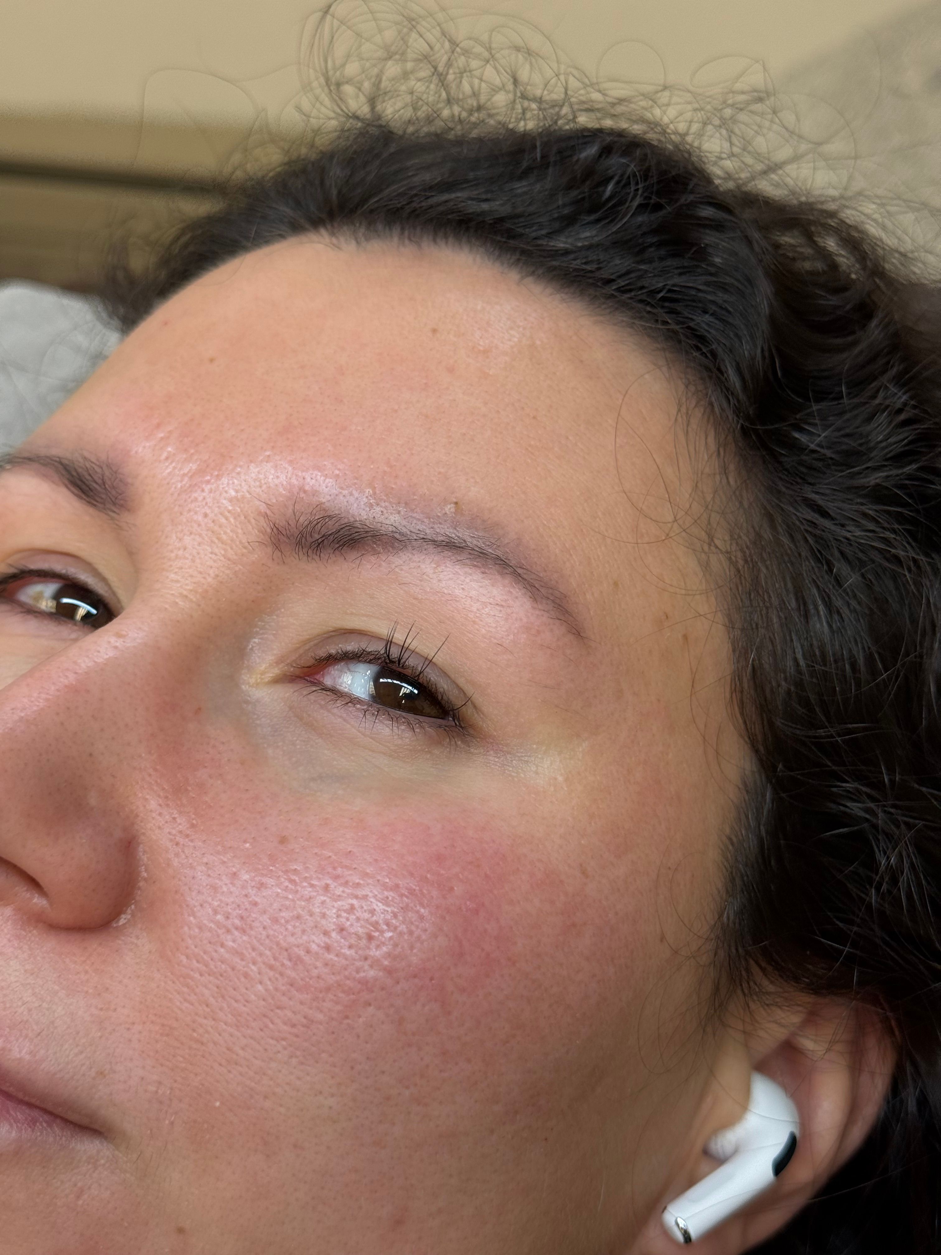 Close-up of a person's left eye with natural eyelashes and a few lash extensions