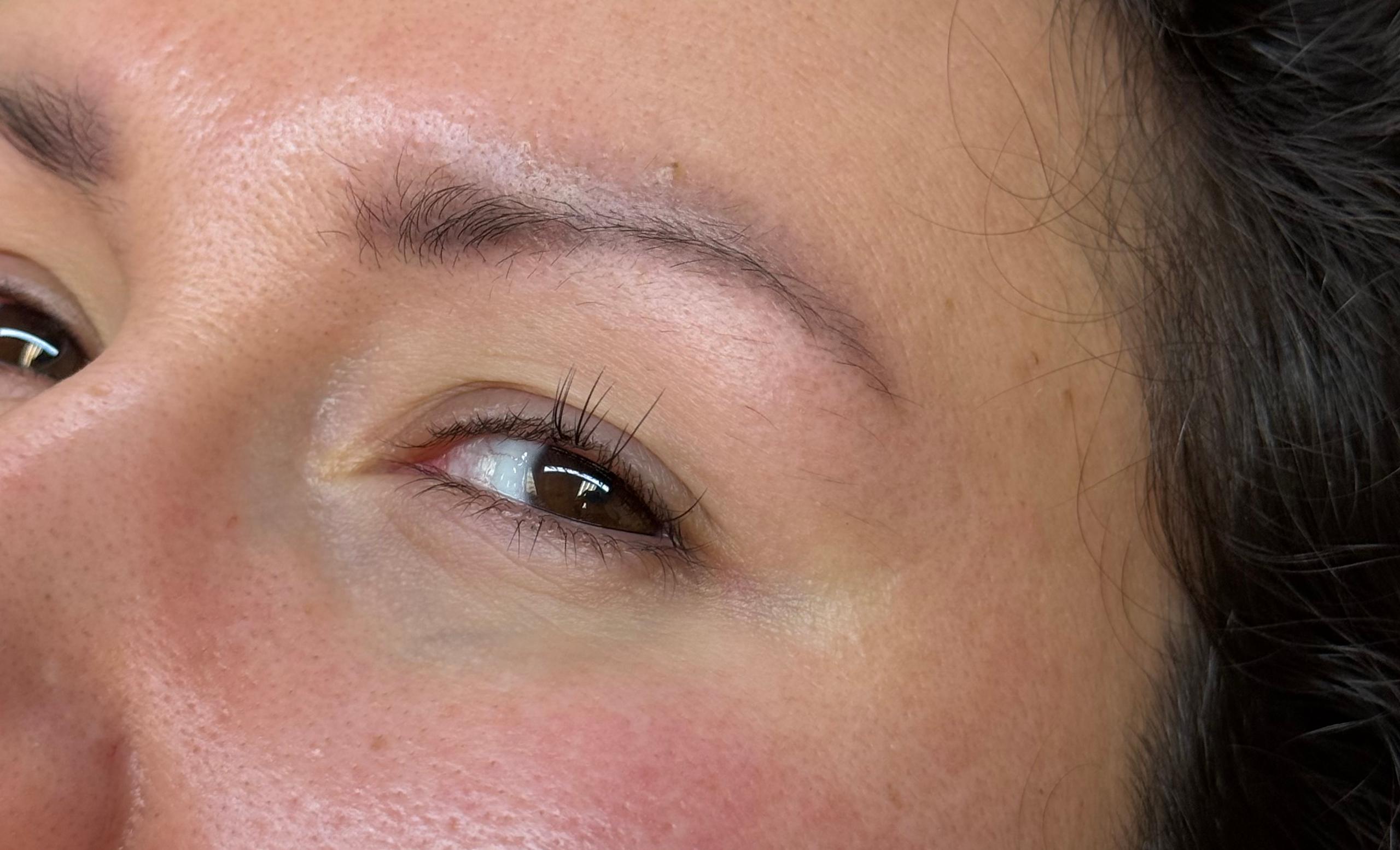 Close-up of a person's left eye with natural eyelashes and a few lash extensions