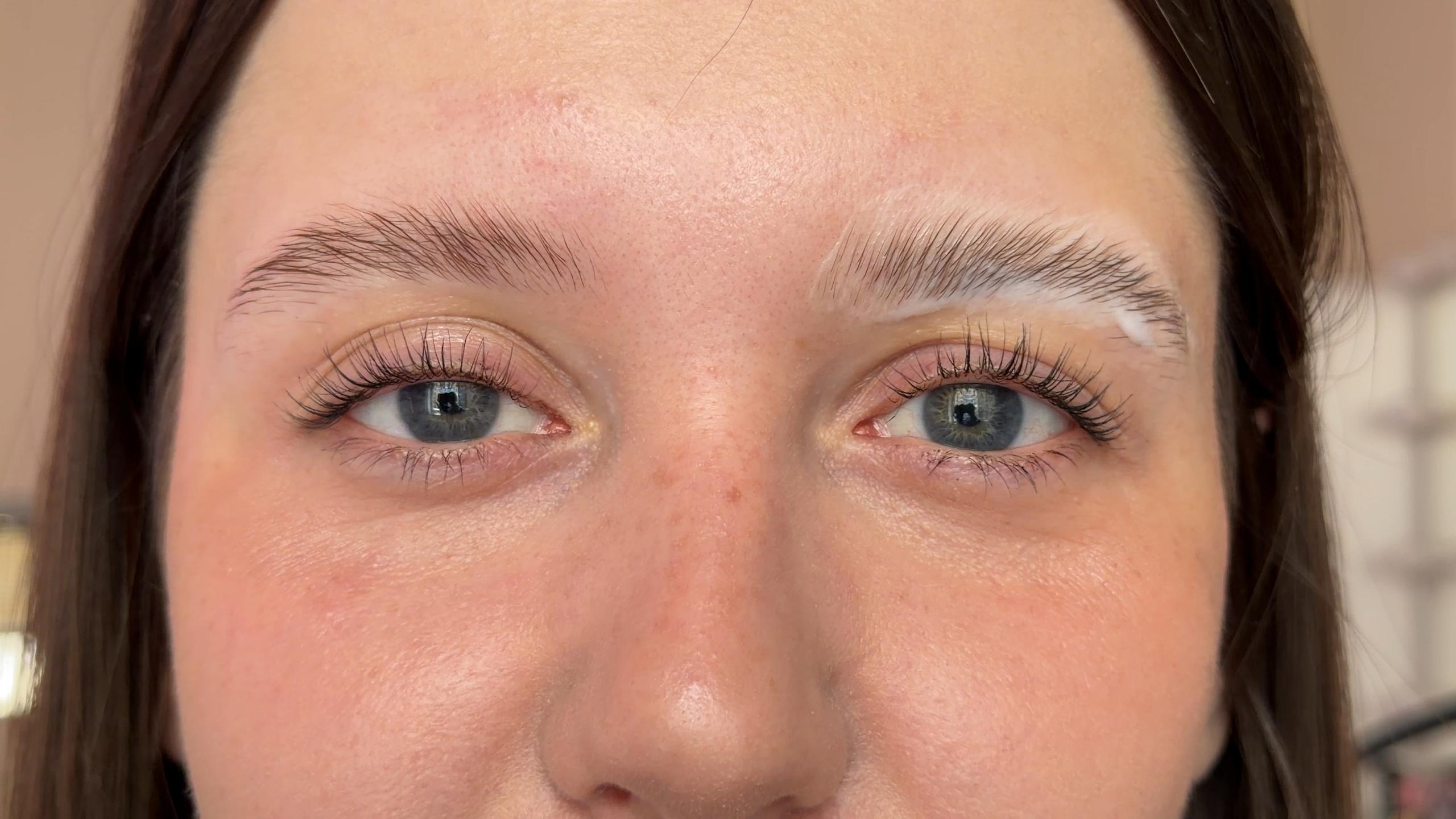 Setting cream coats a client's brushed-up eyebrows during brow lamination.