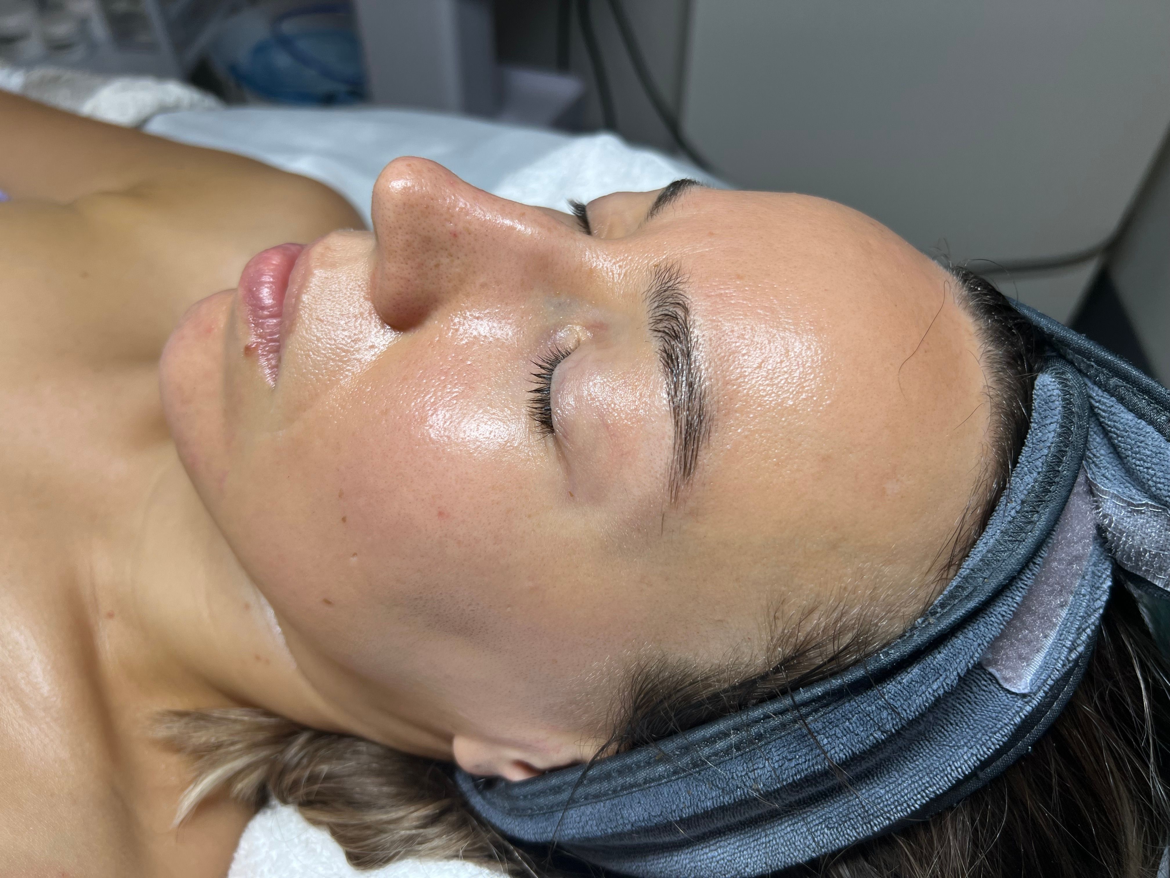 Woman with dewy face and closed eyes wearing a headwrap.