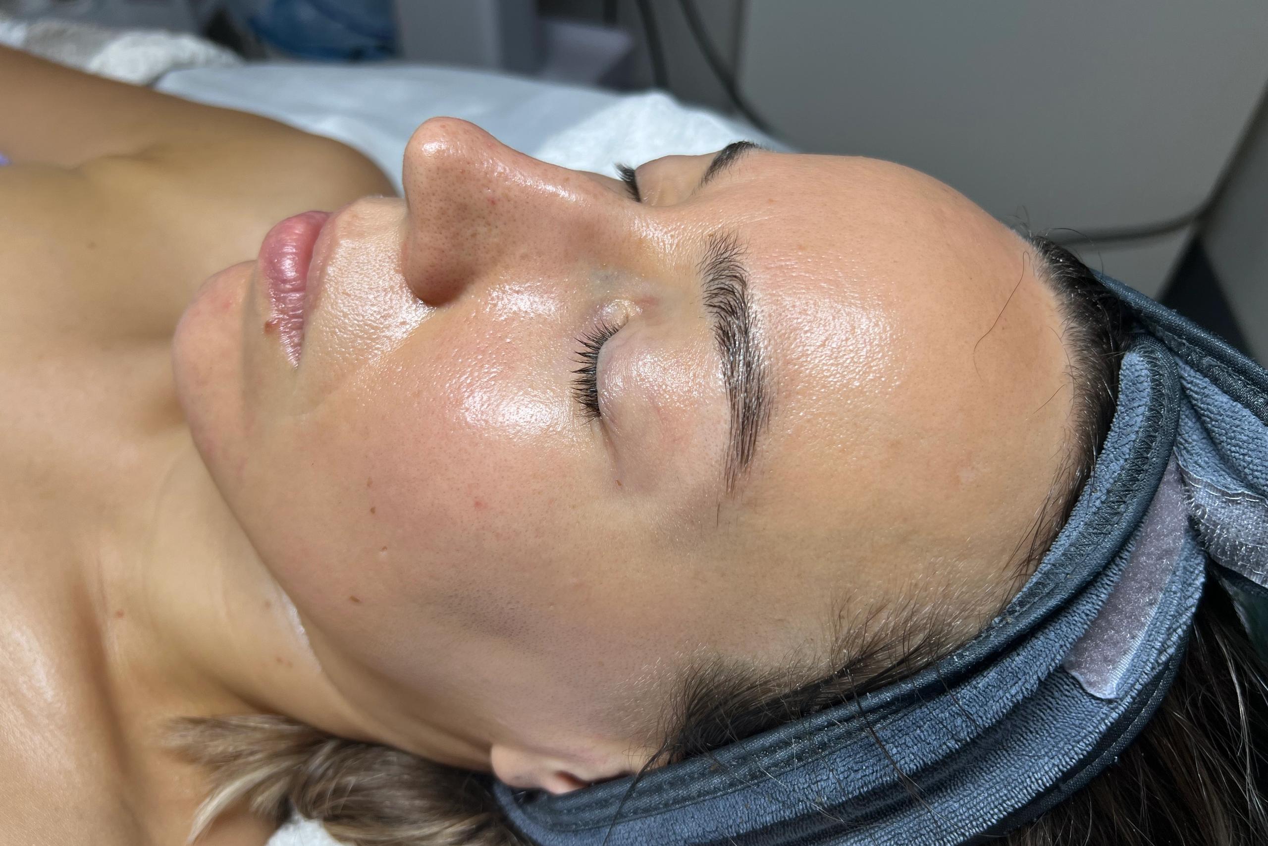 Woman with dewy face and closed eyes wearing a headwrap.