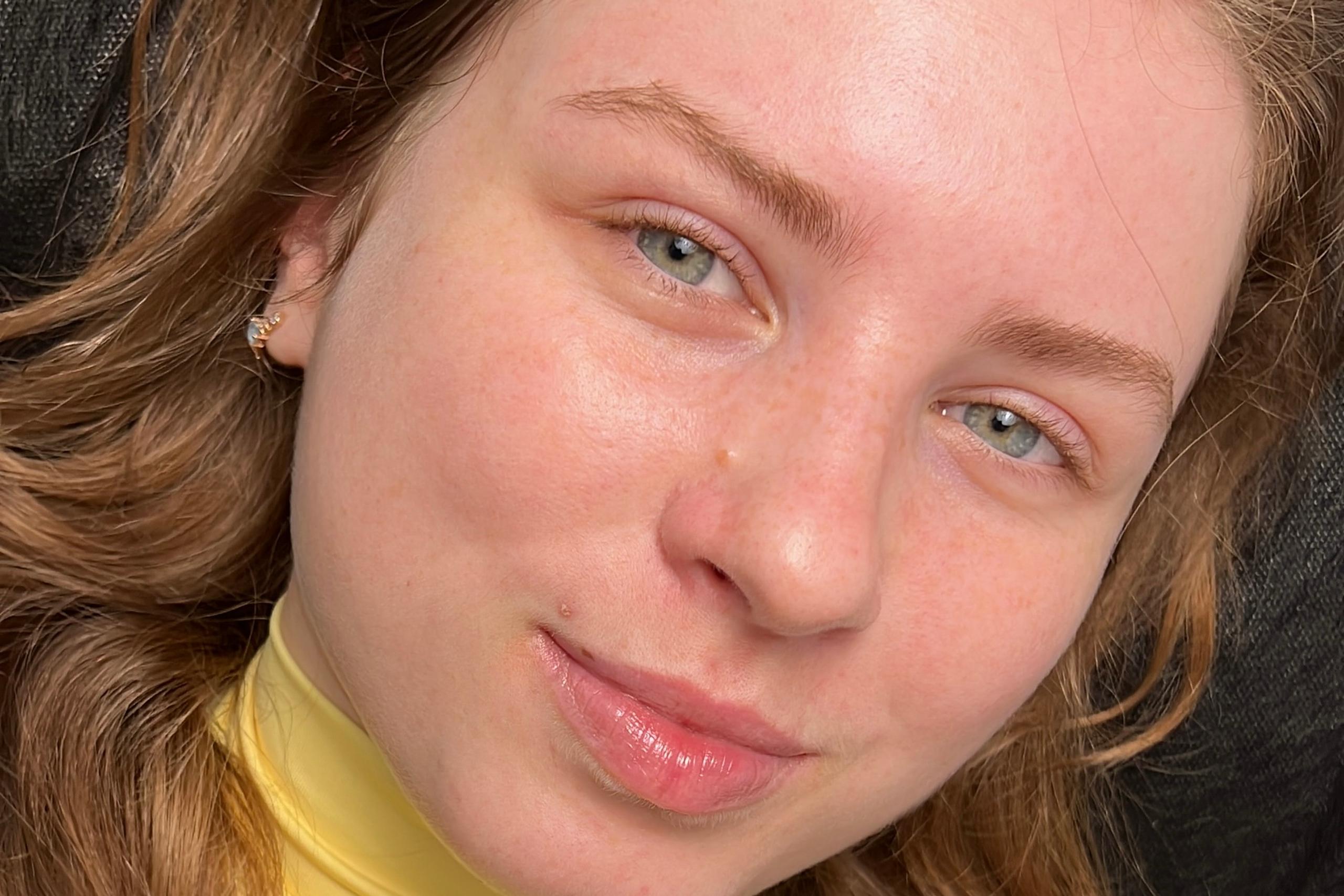 A woman with green eyes and long, light eyelashes lying down