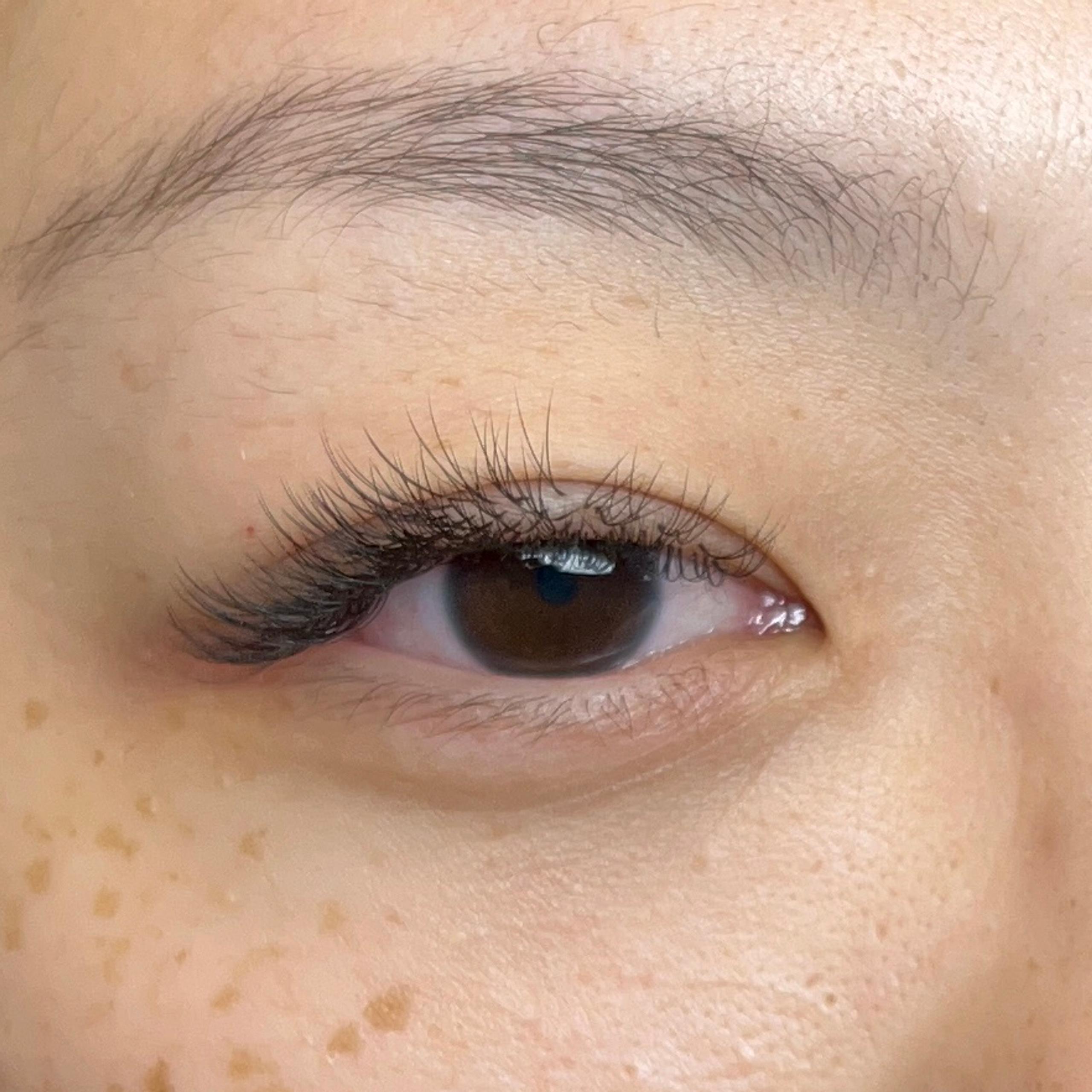 Close-up of a woman's face with long eyelashes and freckles.