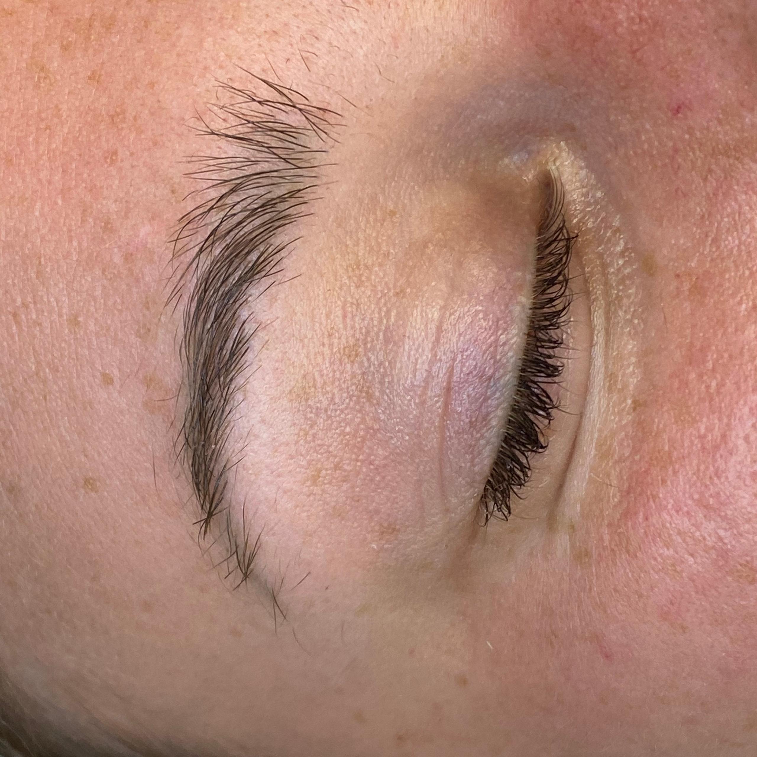 Close-up of a closed eye with a natural eyebrow.