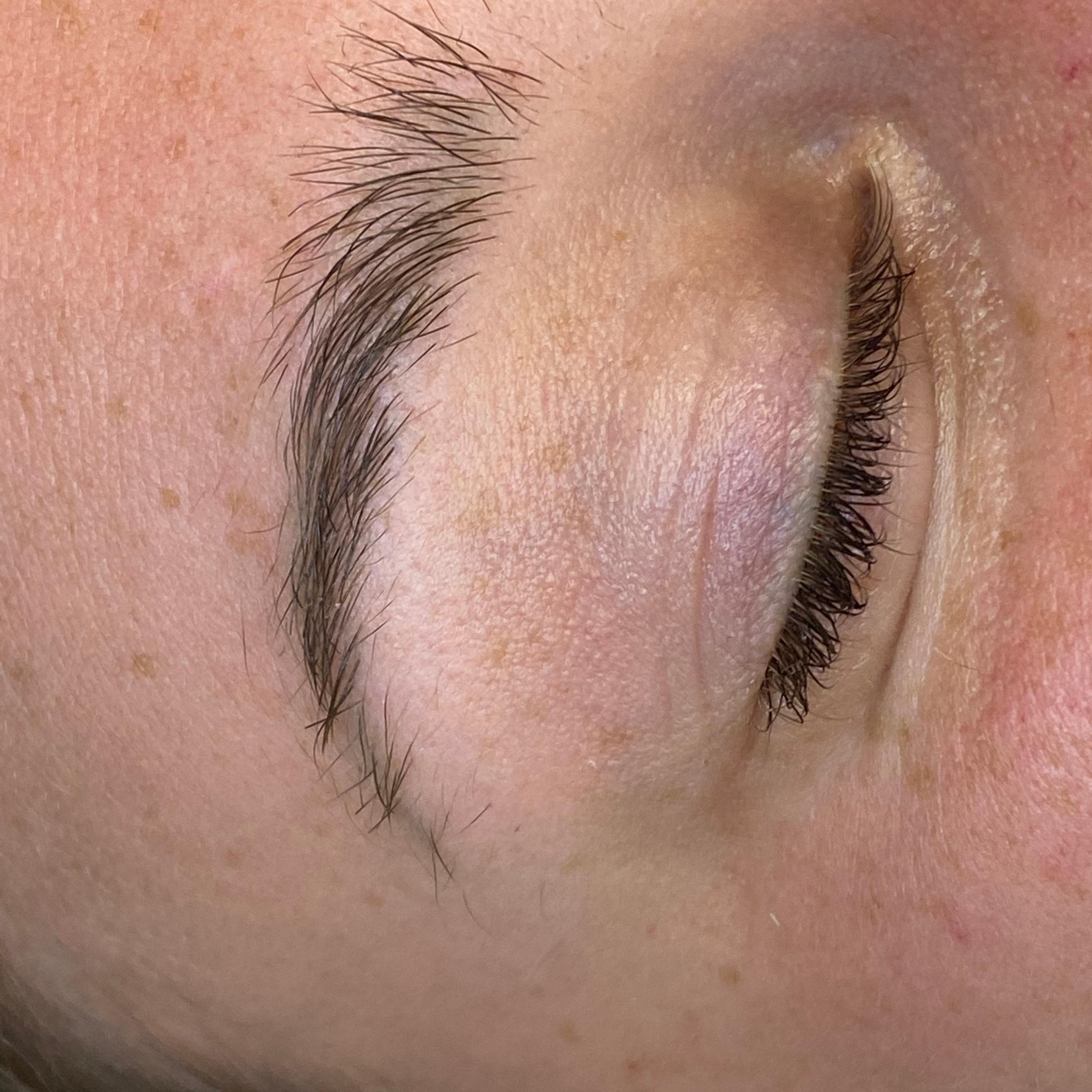 Close-up of a closed eye with a natural eyebrow.