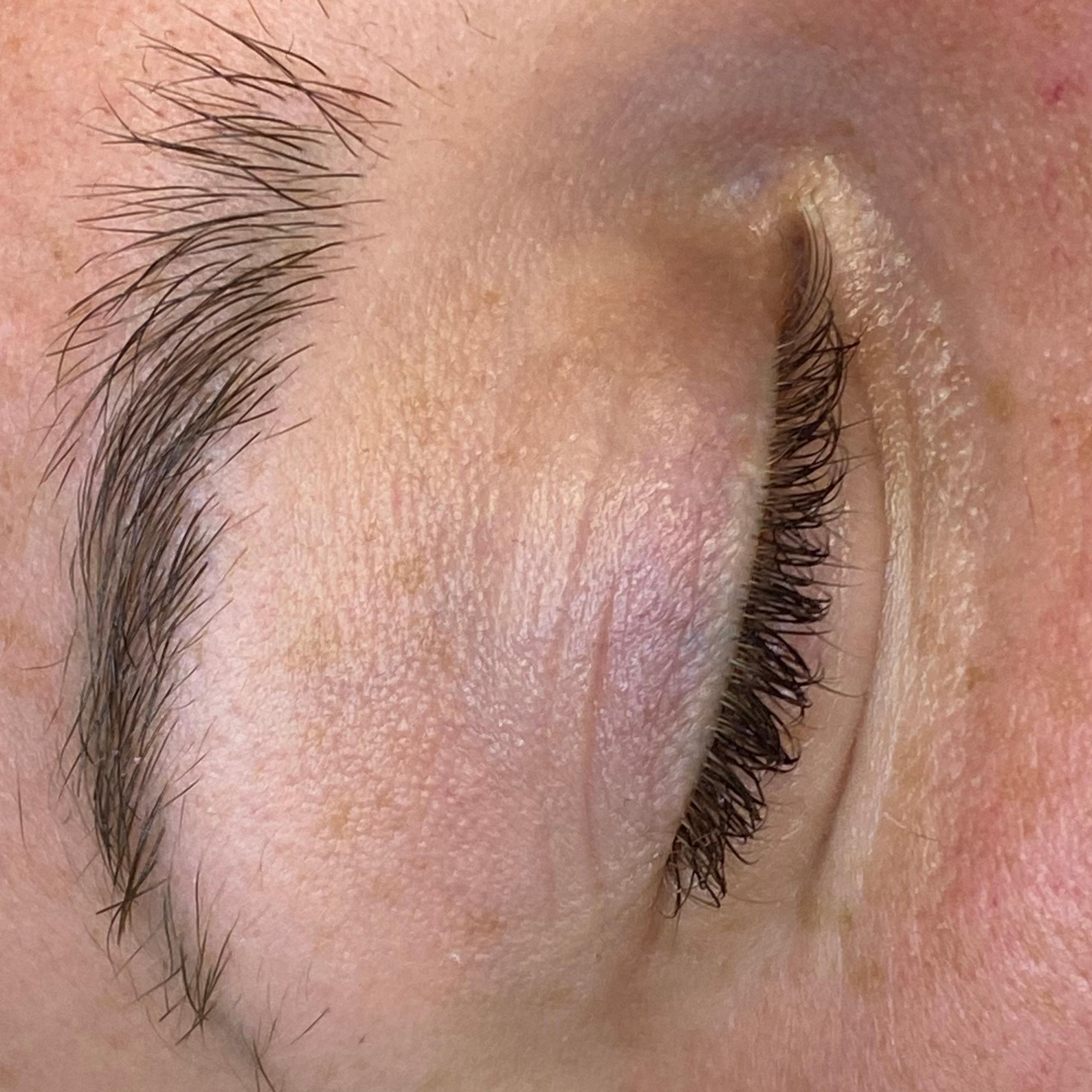Close-up of a closed eye with a natural eyebrow.