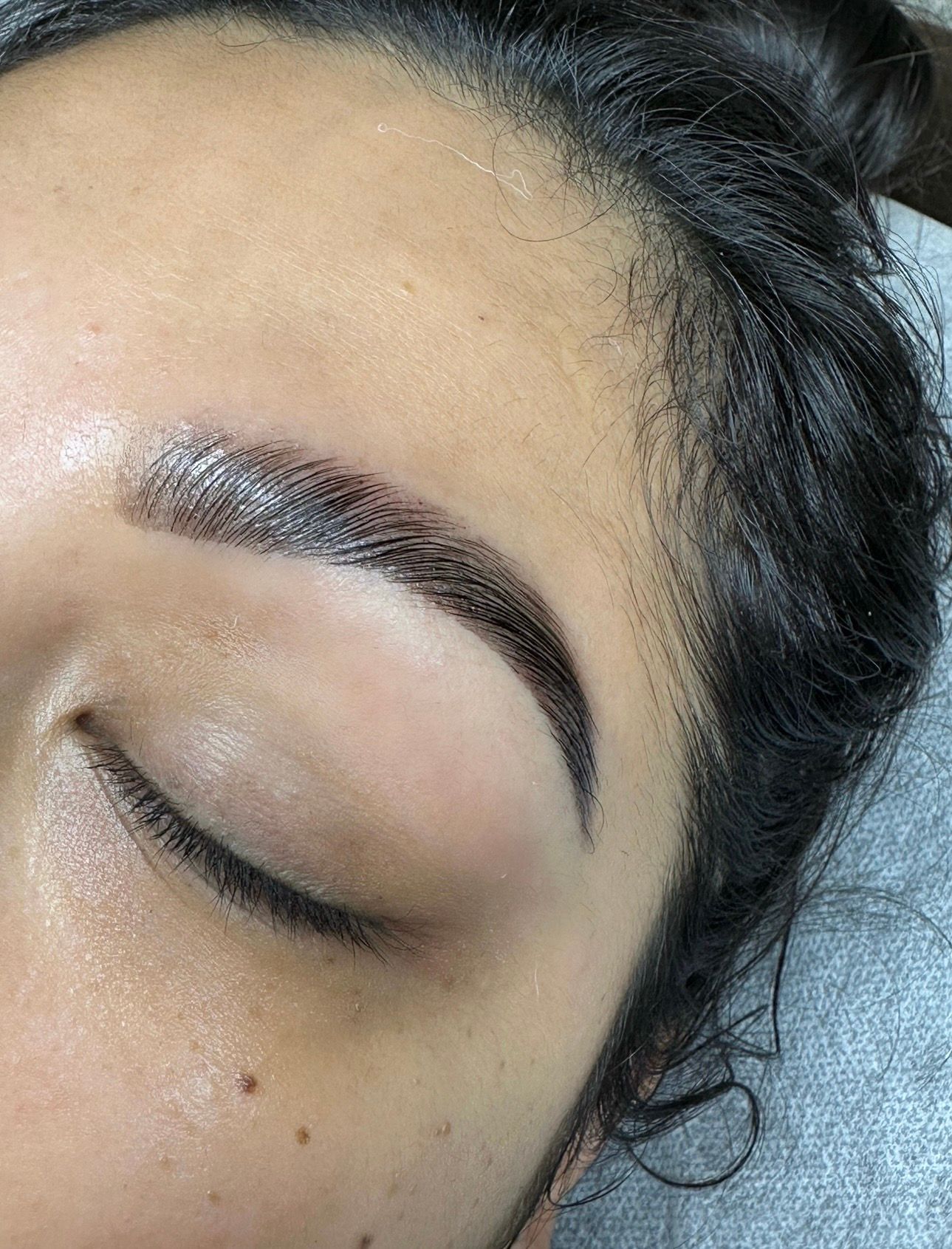 Freshly laminated eyebrow with a closed eye.