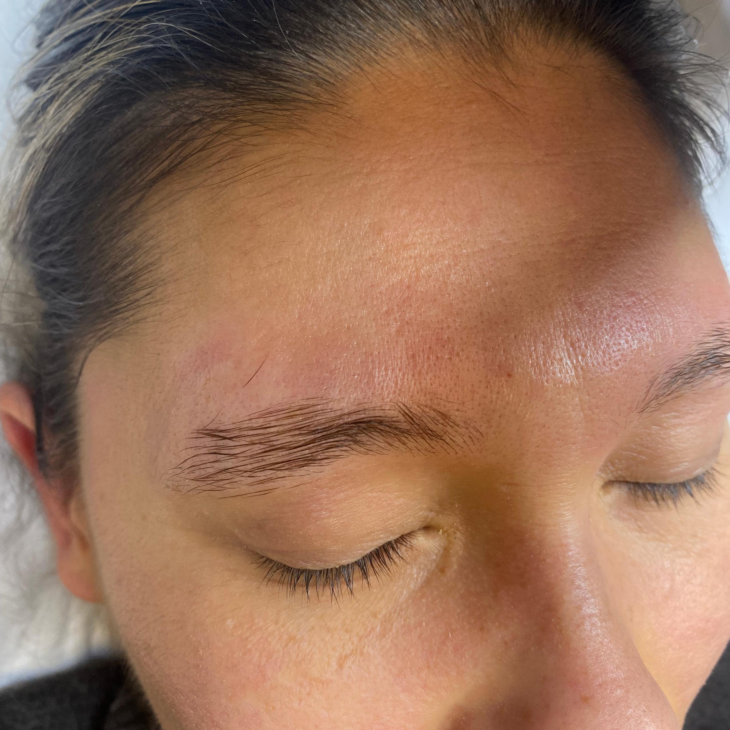 Close-up of a person's face with closed eyes, showing an upward-brushed eyebrow