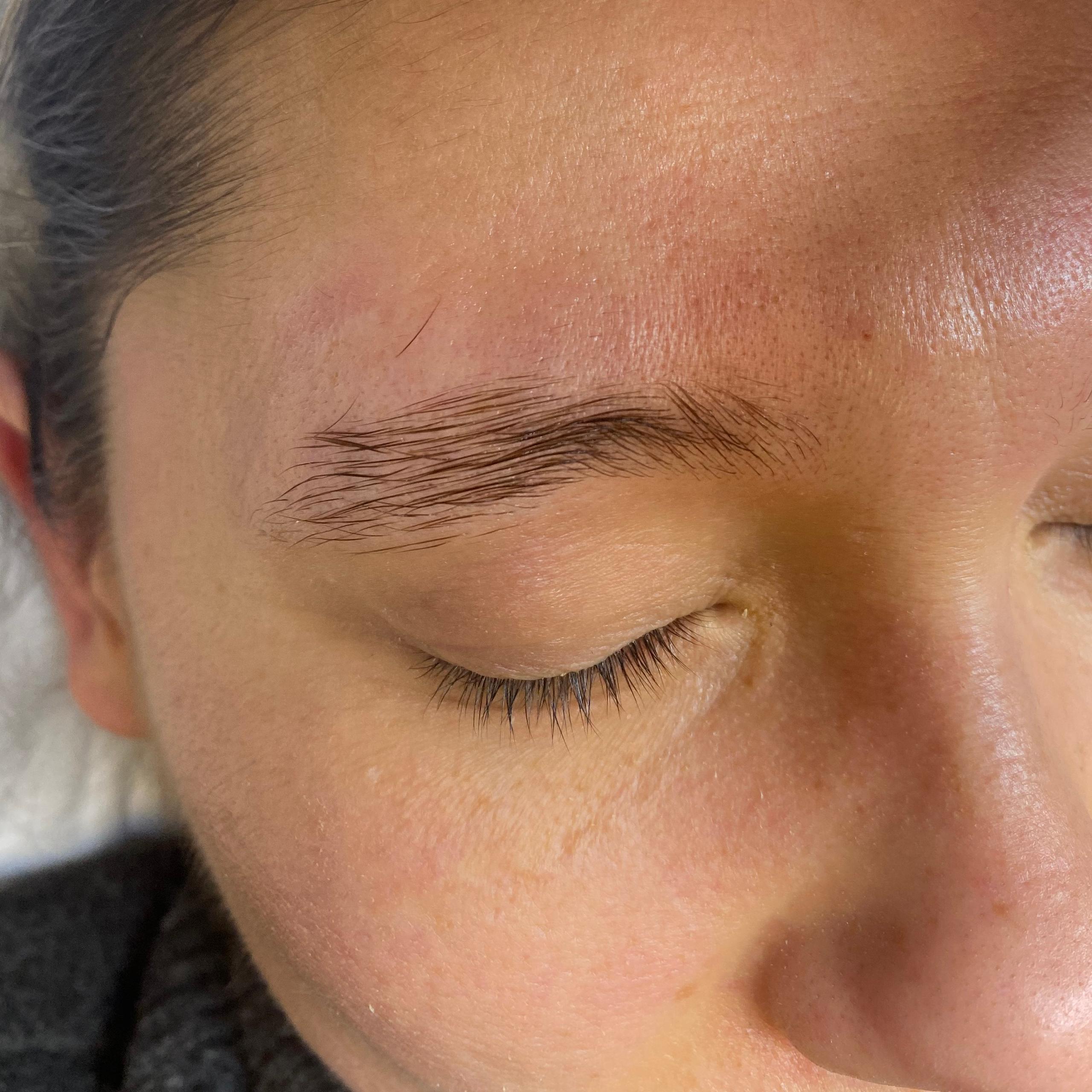 Close-up of a person's face with closed eyes, showing an upward-brushed eyebrow