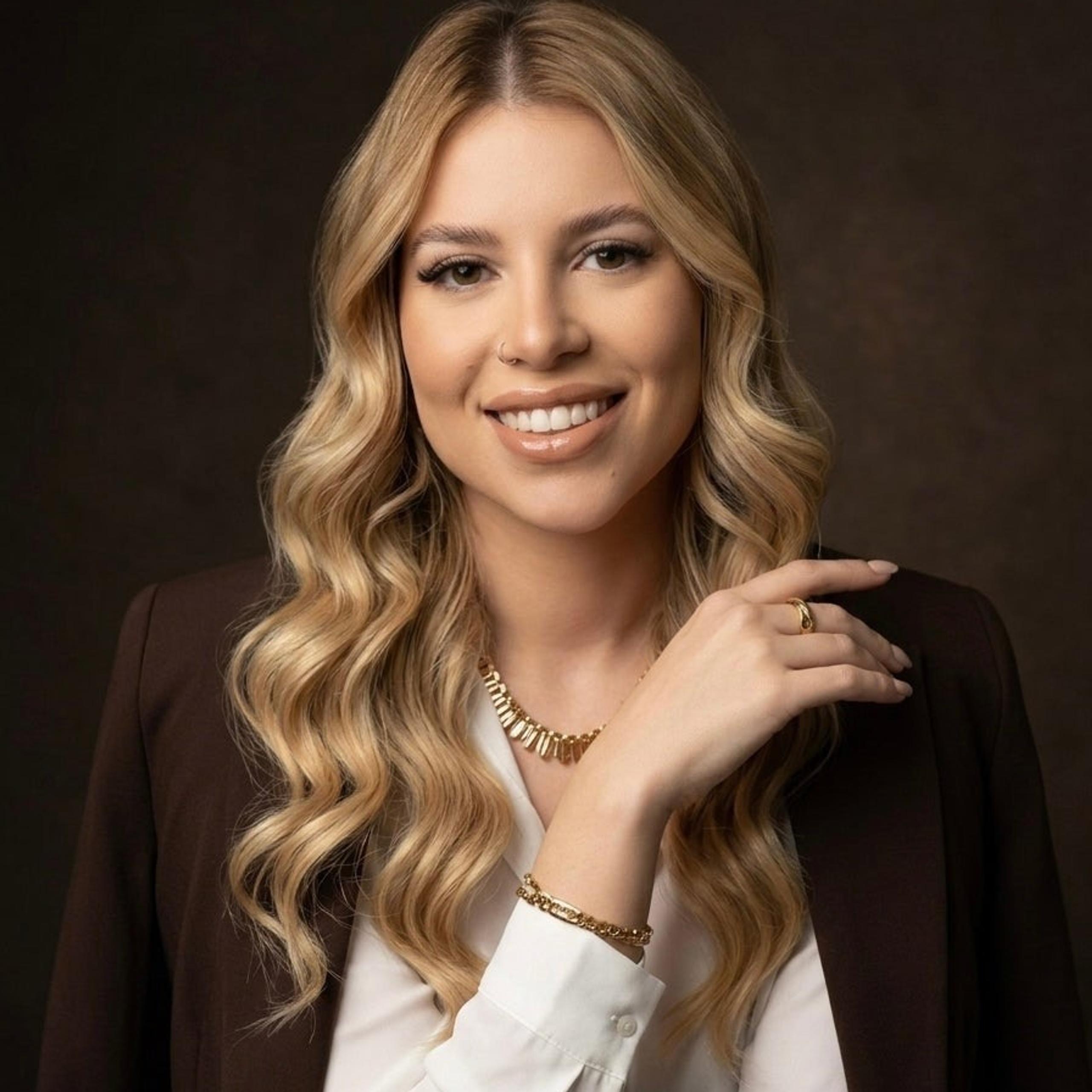 A portrait of a smiling woman with curly blond hair