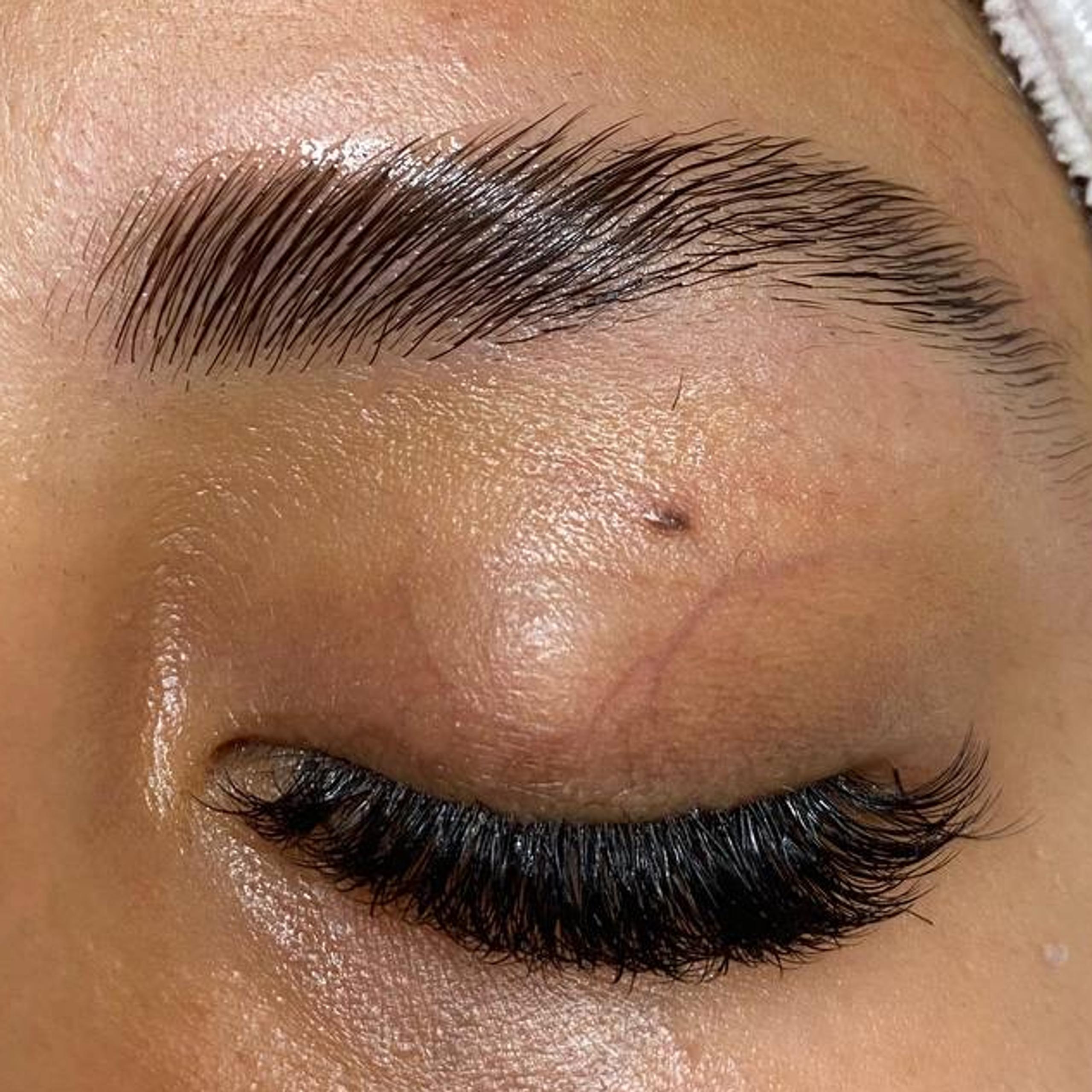 Close-up of a closed eye with a laminated brow