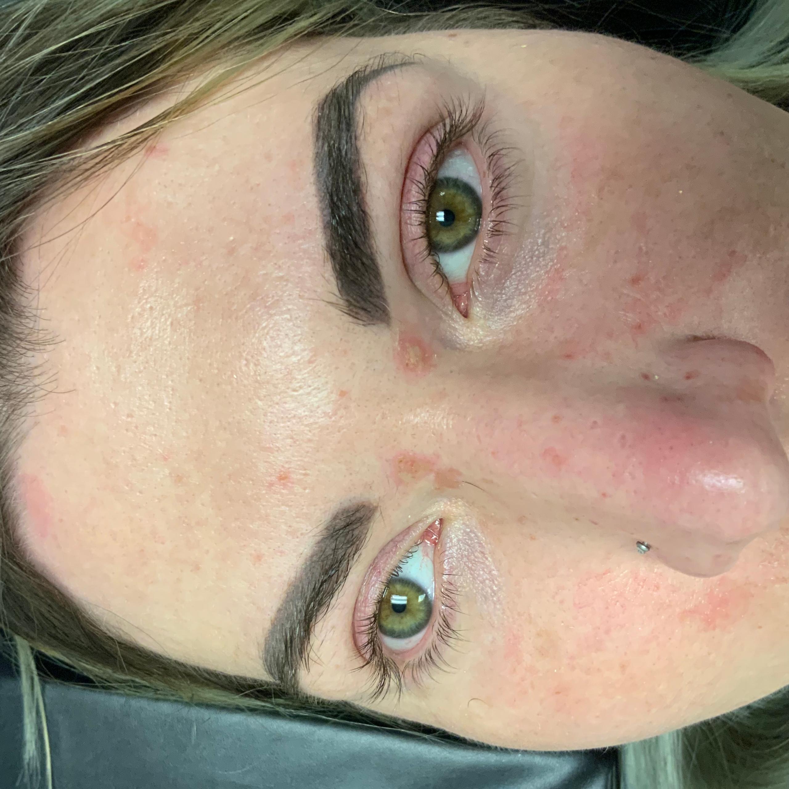 Aperson's face with green eyes and dark eyebrows