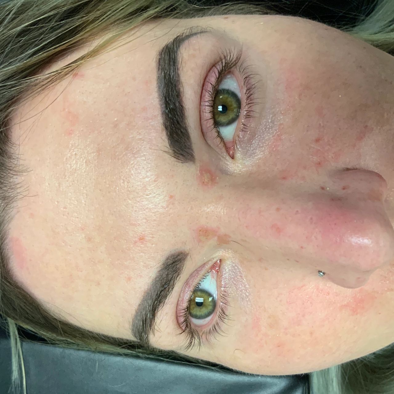 Aperson's face with green eyes and dark eyebrows