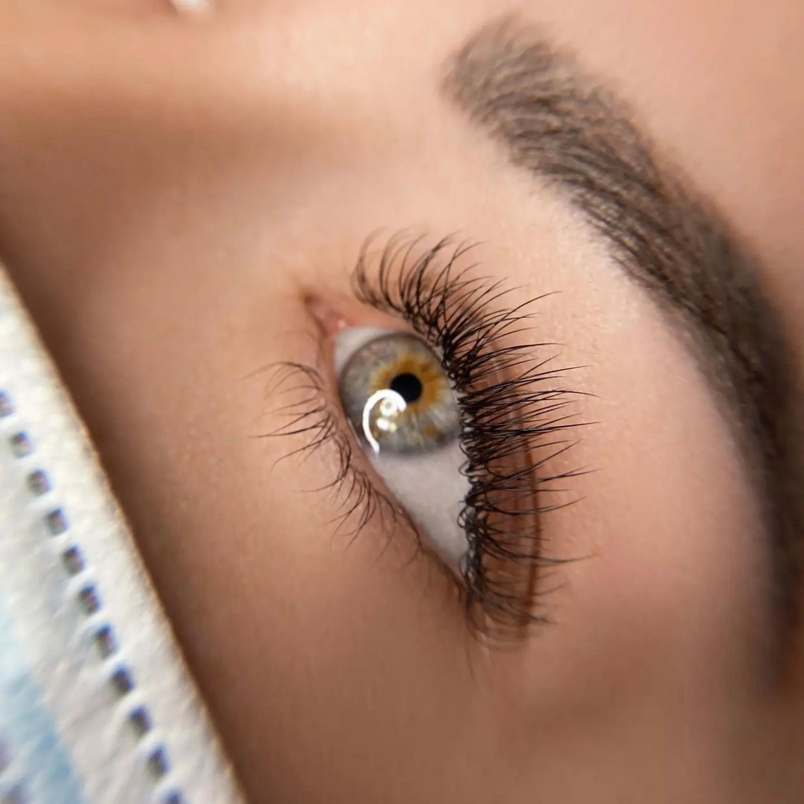 Close-up of an eye with long eyelashes and a hazel iris.