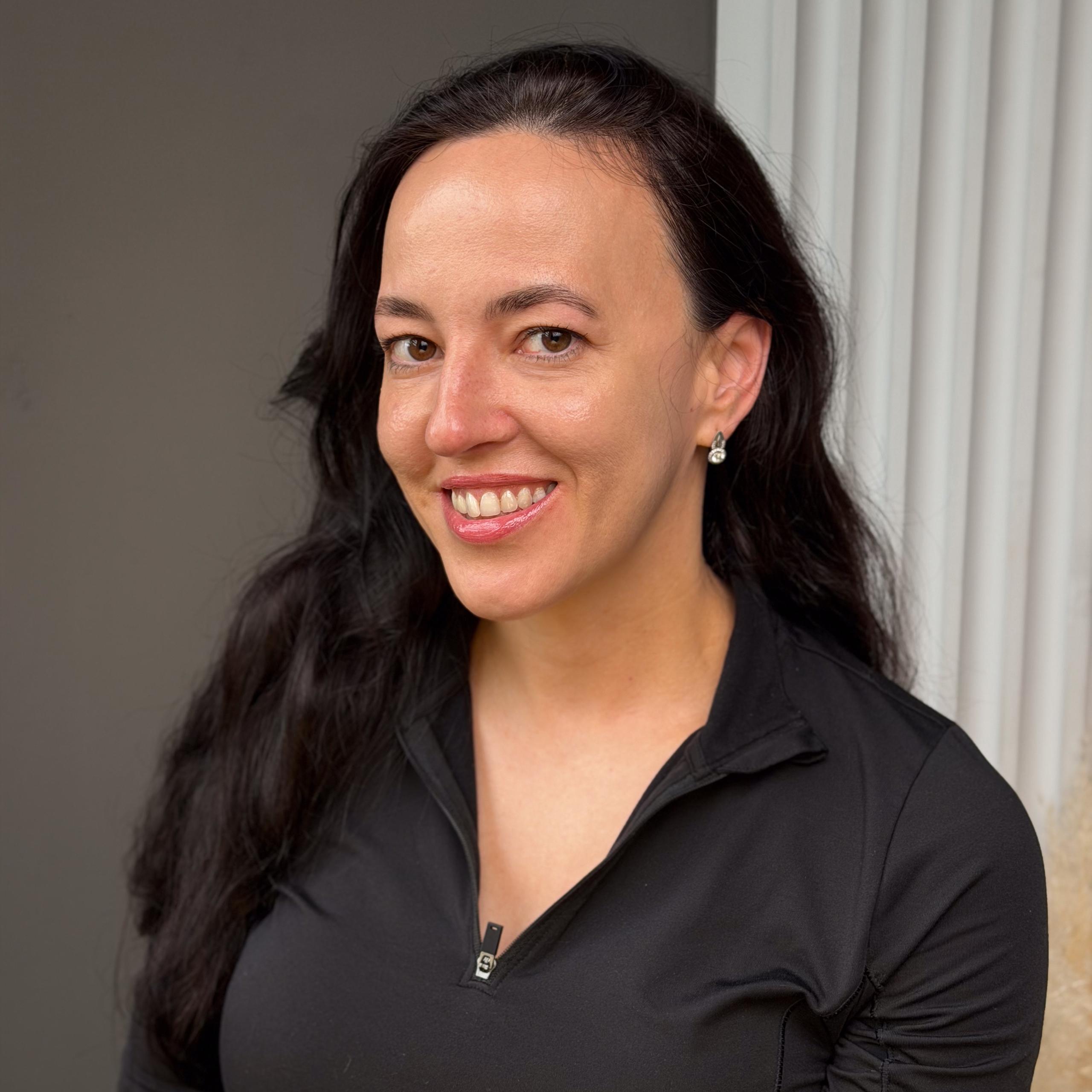 A portrait of a smiling woman with a defined eyebrows