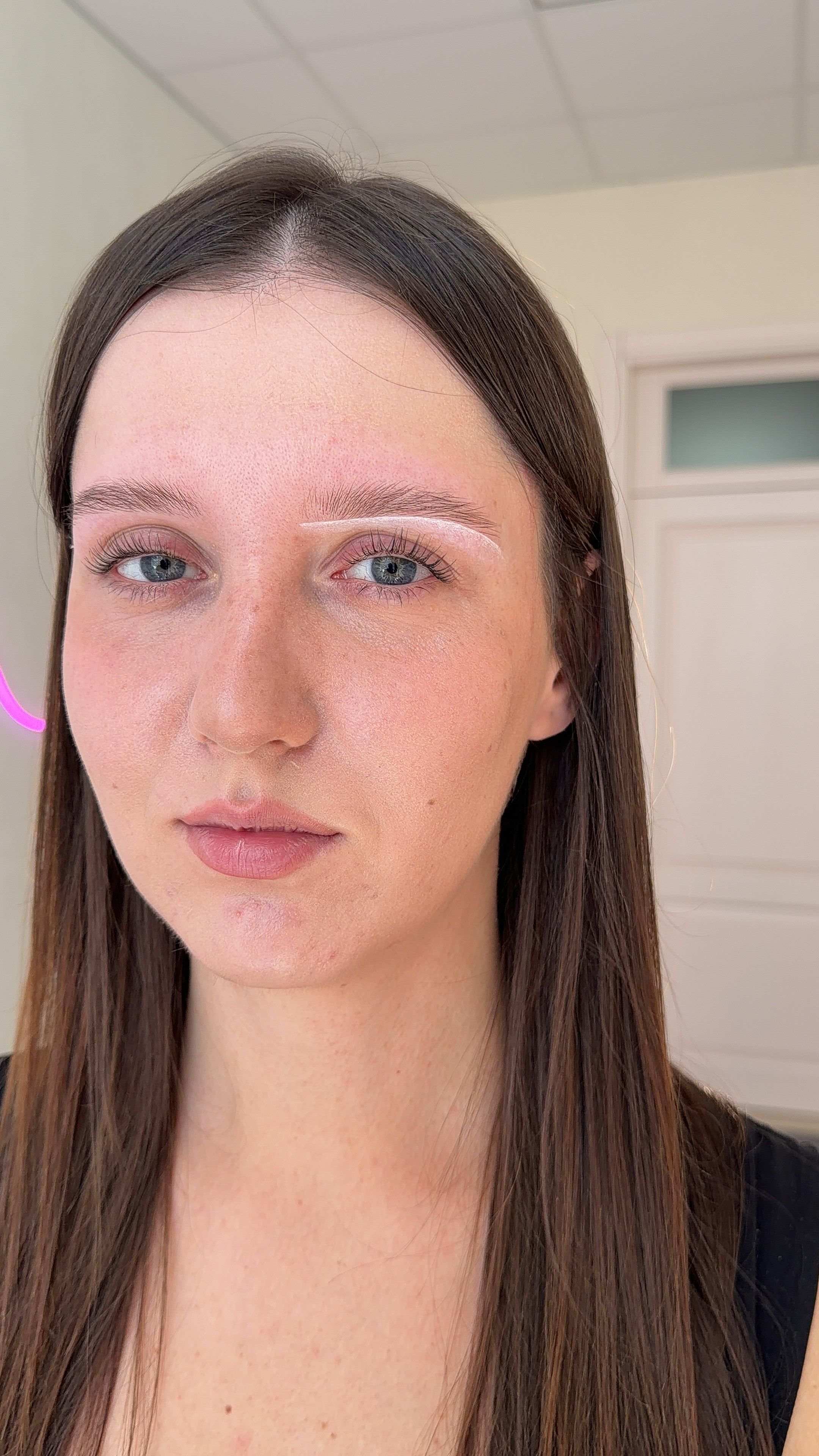 White mapping lines outline the planned shape around a client's eyebrow.