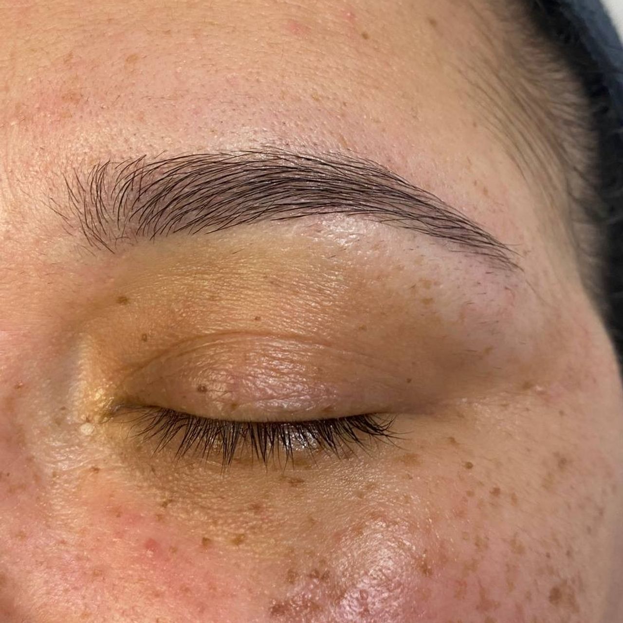 Close-up of a closed eye with a light brown eyebrows