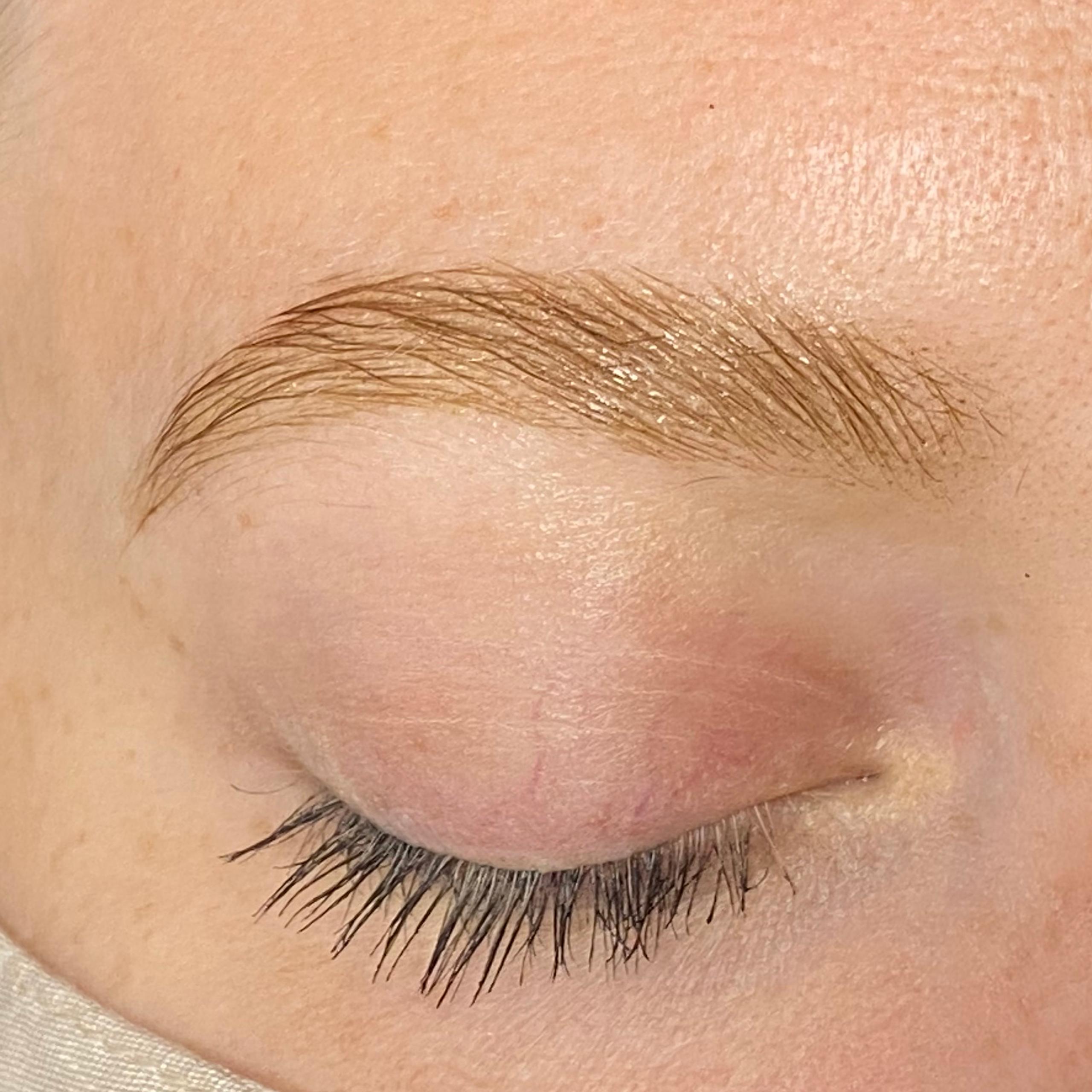 Close-up of a person's face with closed eyes, well-groomed eyebrows