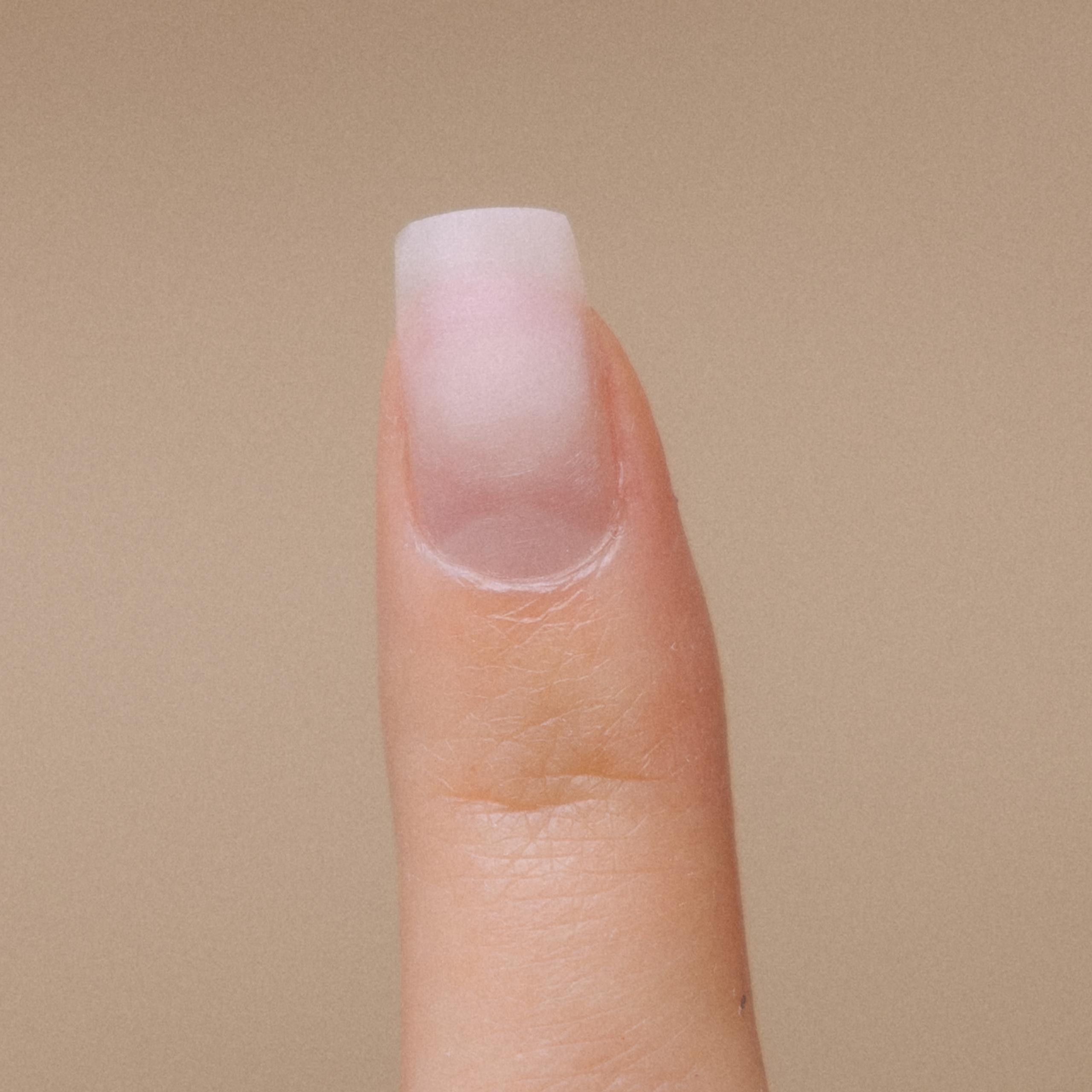 A hand with an index finger with no polish pointing upwards.