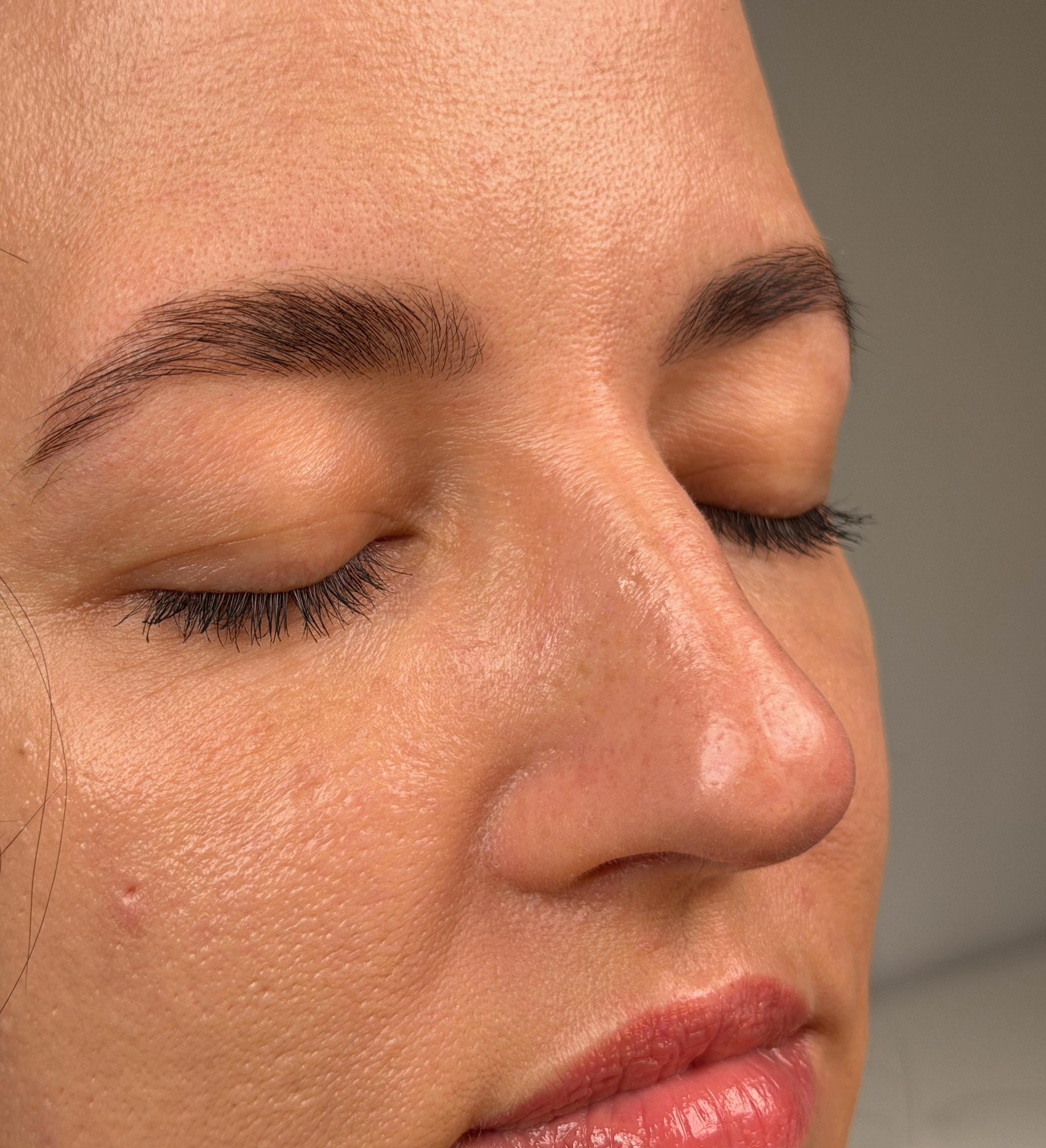 Close-up of a client with smooth, defined eyebrows after brow lamination.