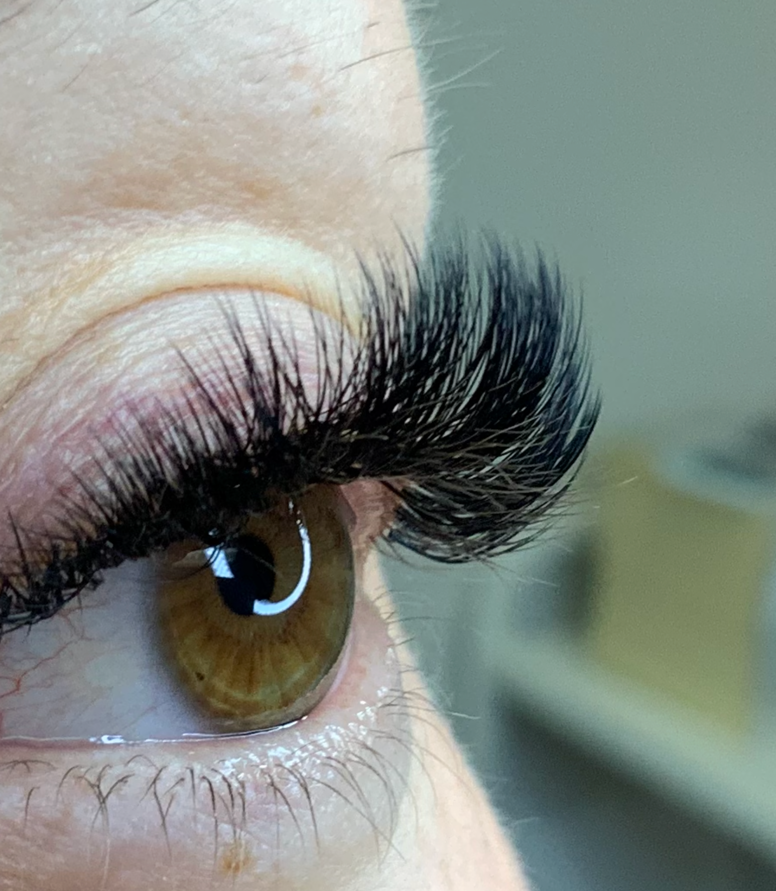 Close-up of a brown eye with dramatic, voluminous black eyelash extensions.