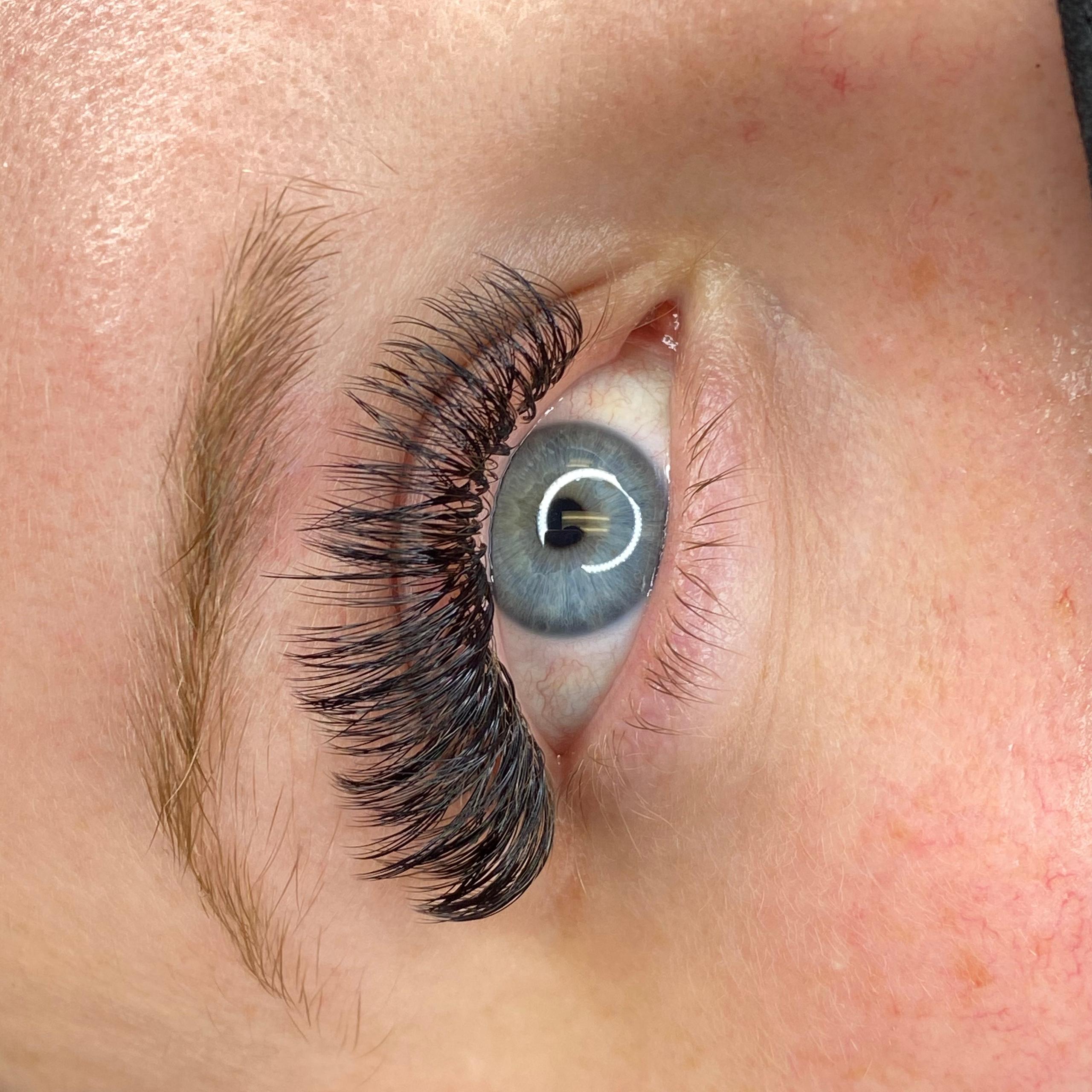Close-up of a blue eye with long, voluminous false eyelashes.