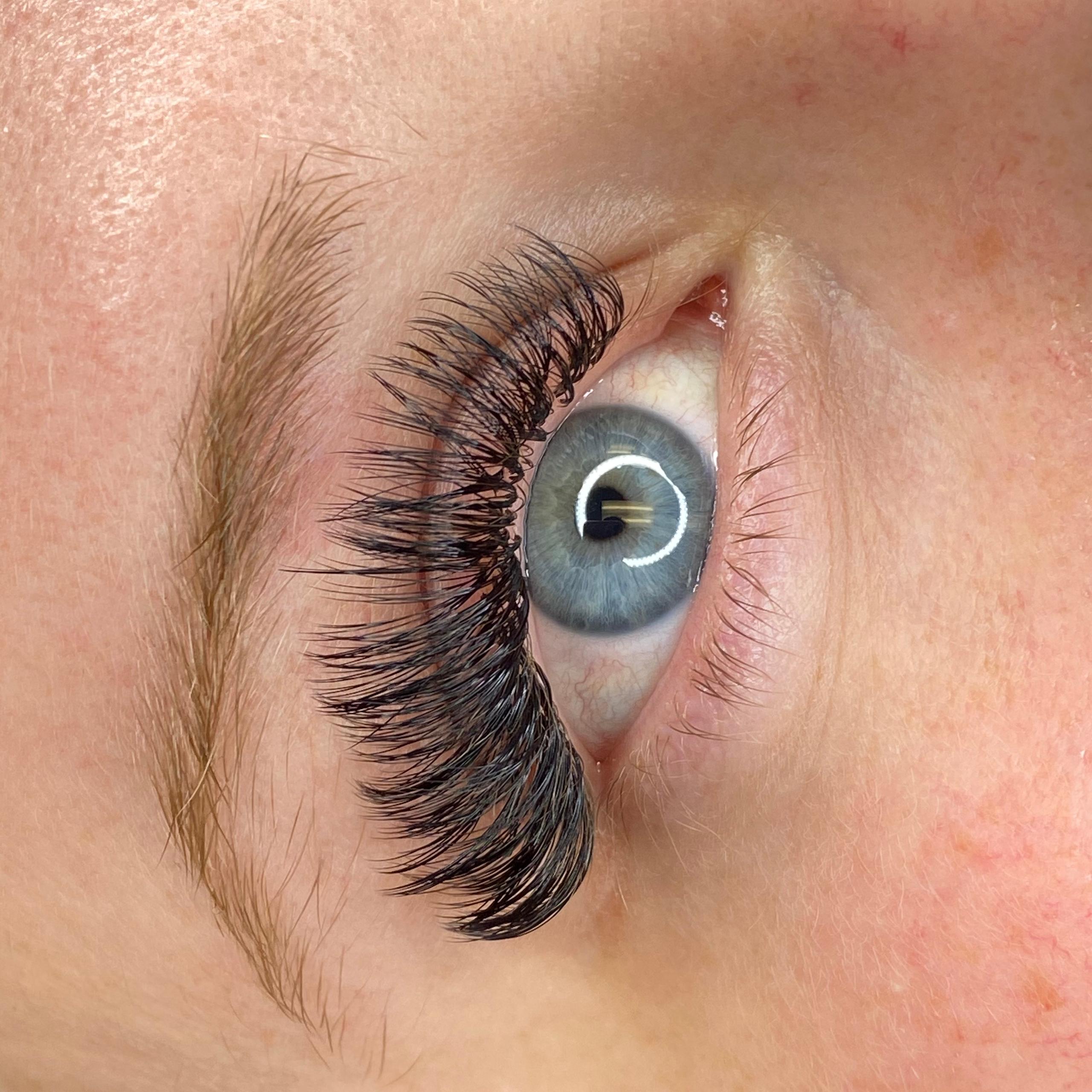 Close-up of a blue eye with long, voluminous false eyelashes.