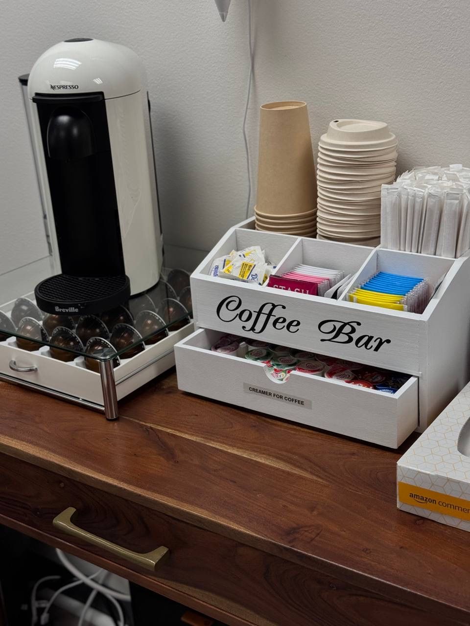 Beauty Republic coffee station with a Nespresso machine, paper cups, tea, and coffee supplies.