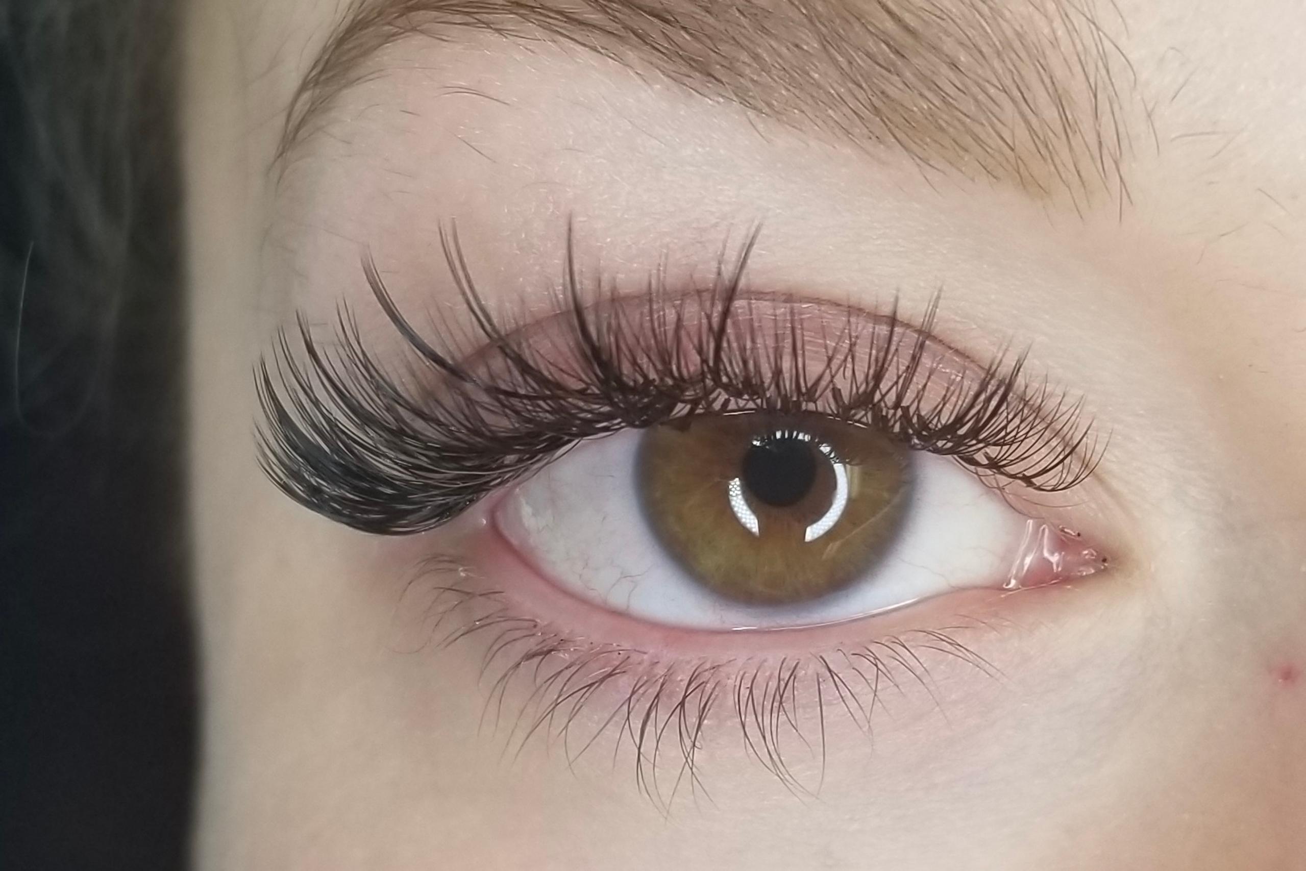 Close-up of an eye with long, dark, wispy eyelashes