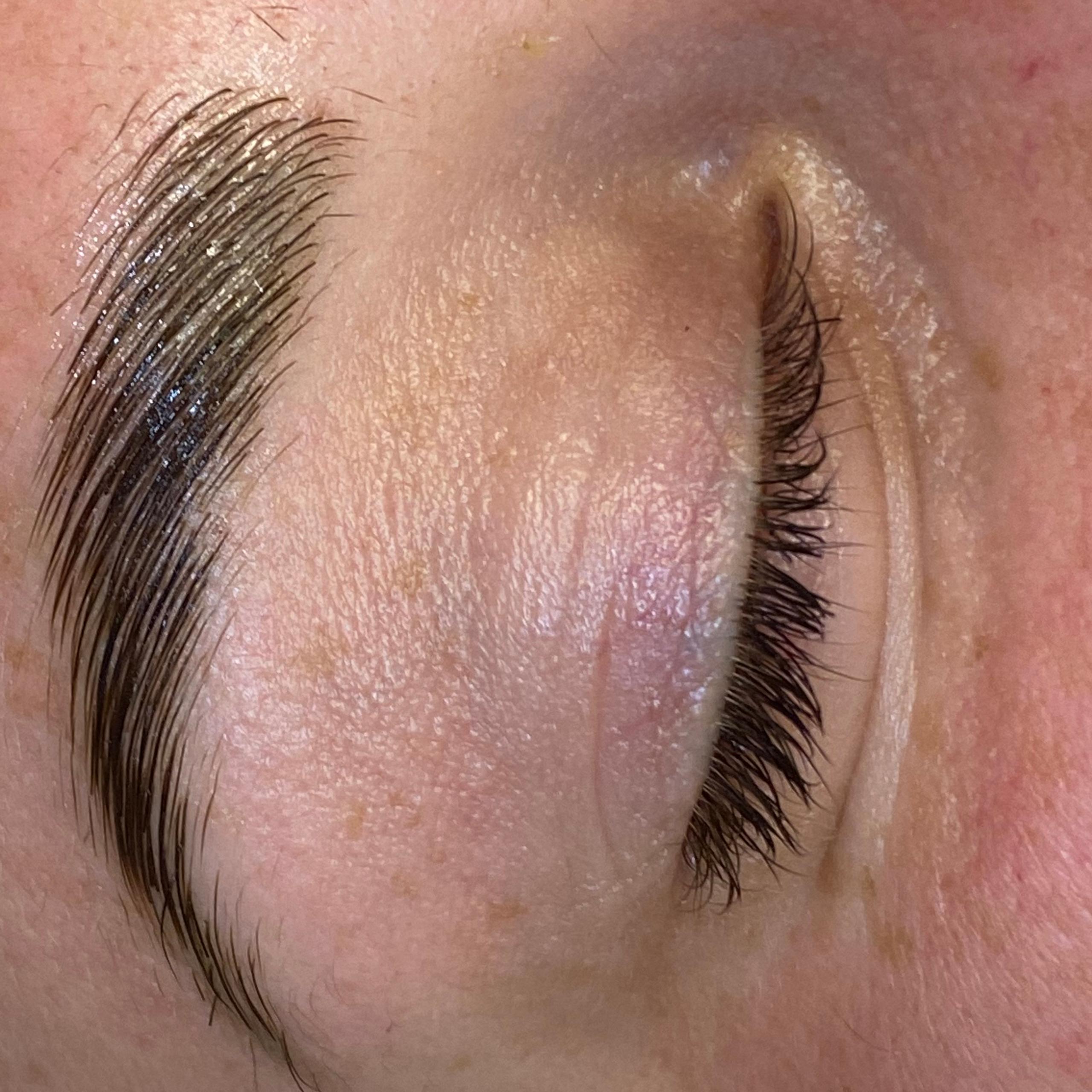 Close-up of a person's laminated eyebrow and closed eye.