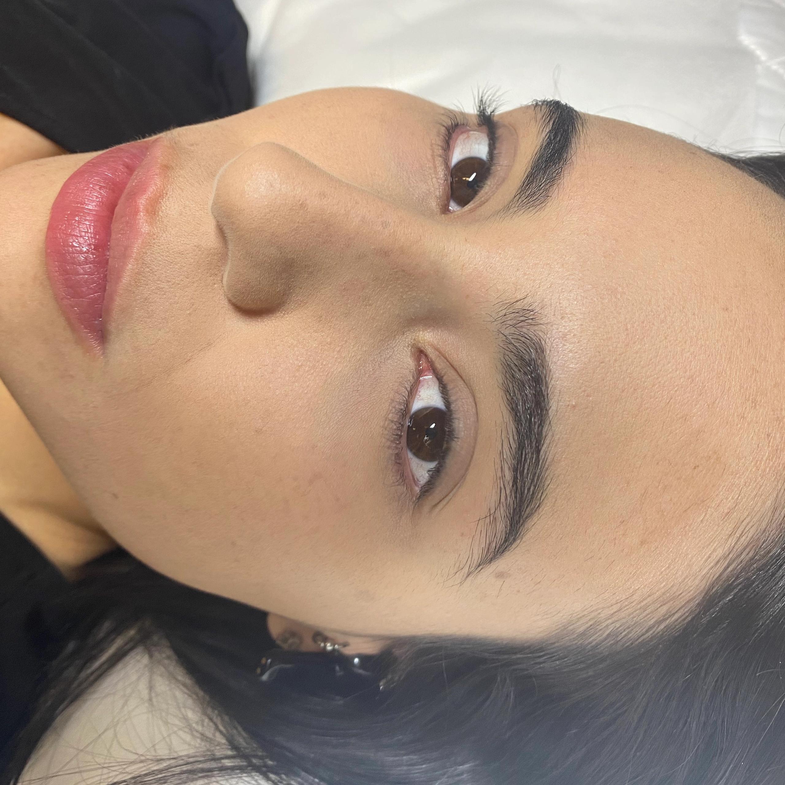 Close-up of a woman's face with subtle pink lip blush.