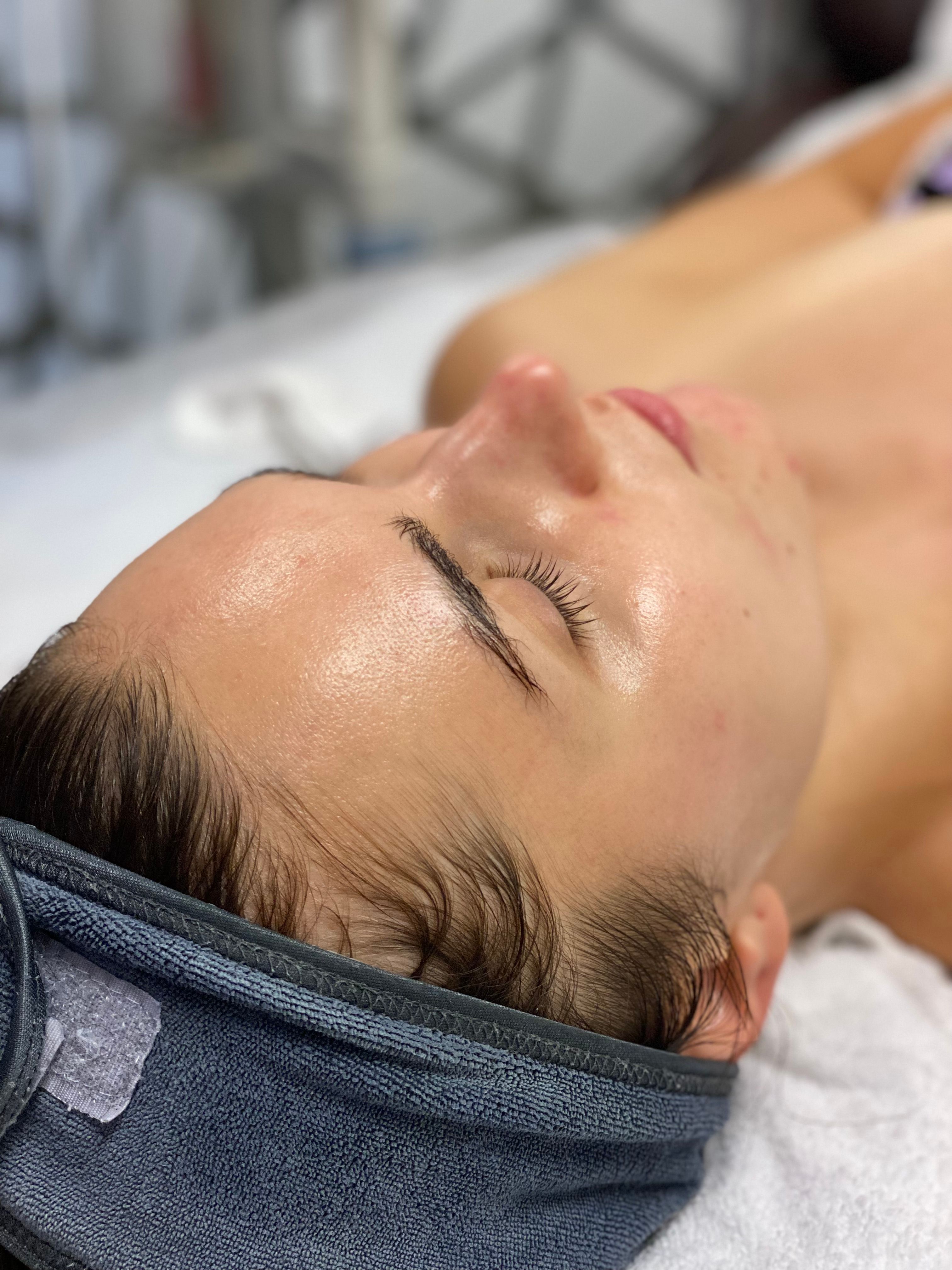 Close-up of a client resting with eyes closed, skin glowing after a facial.