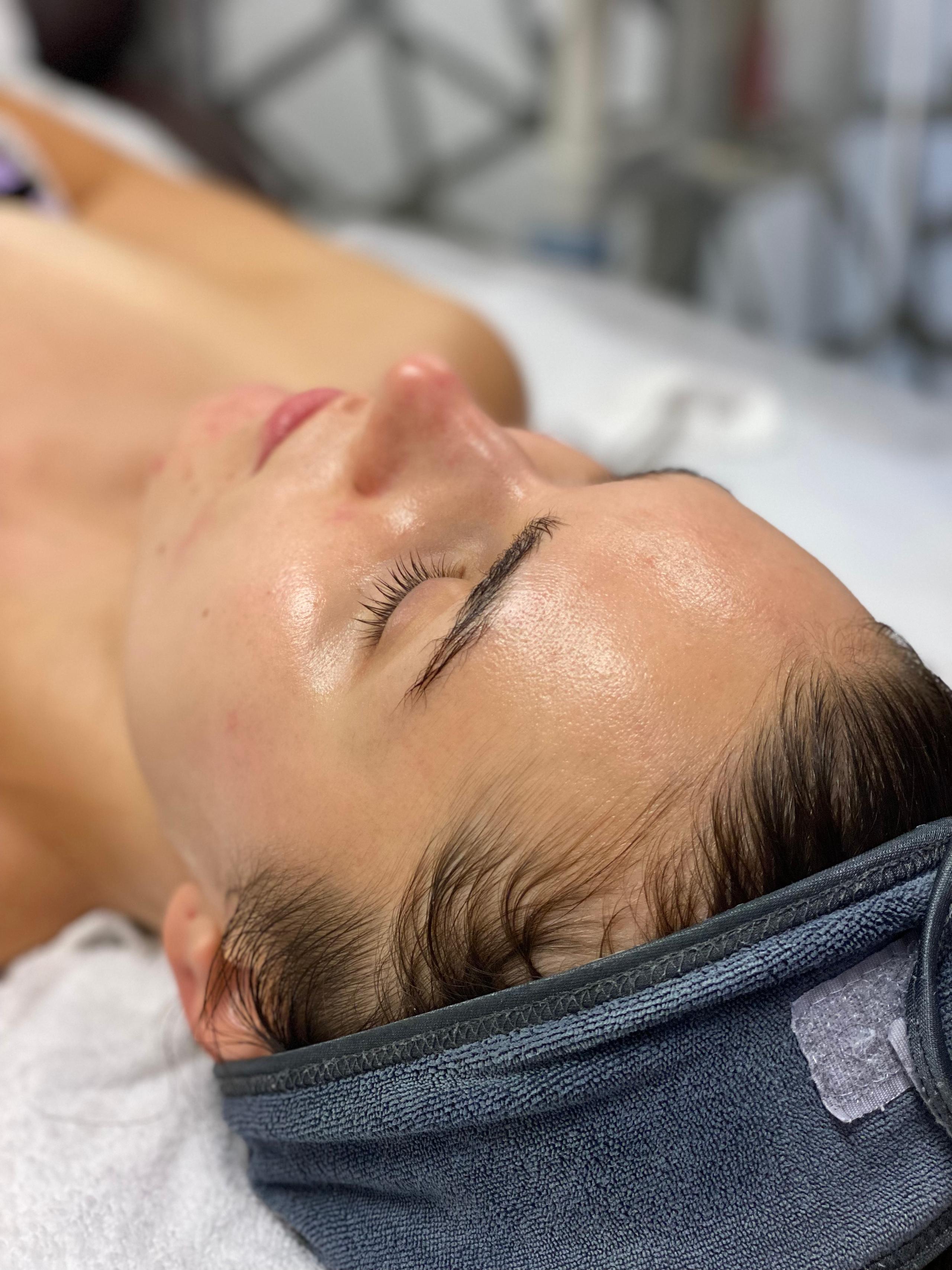 Close-up of a client resting with eyes closed, skin glowing after a facial.