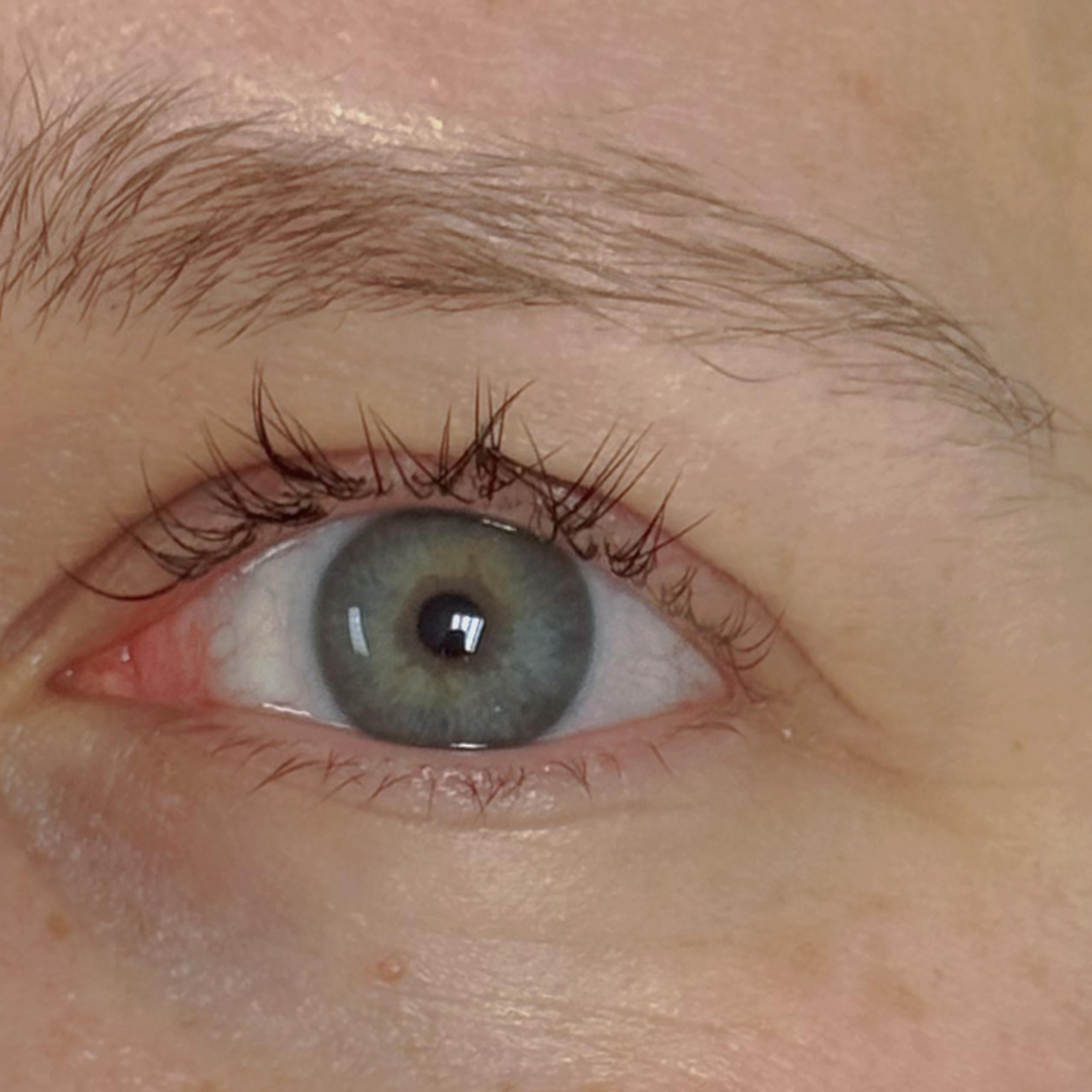 Close-up of a woman's right eye and a faint smile
