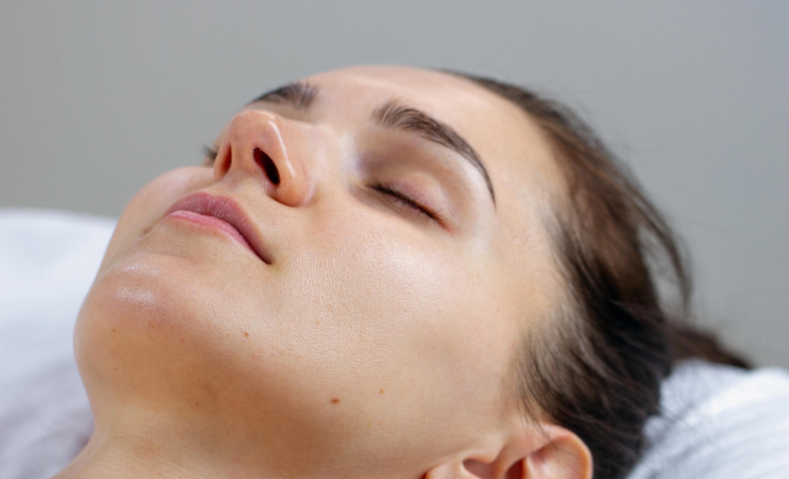 Close-up of a woman with closed eyes, looking relaxed.